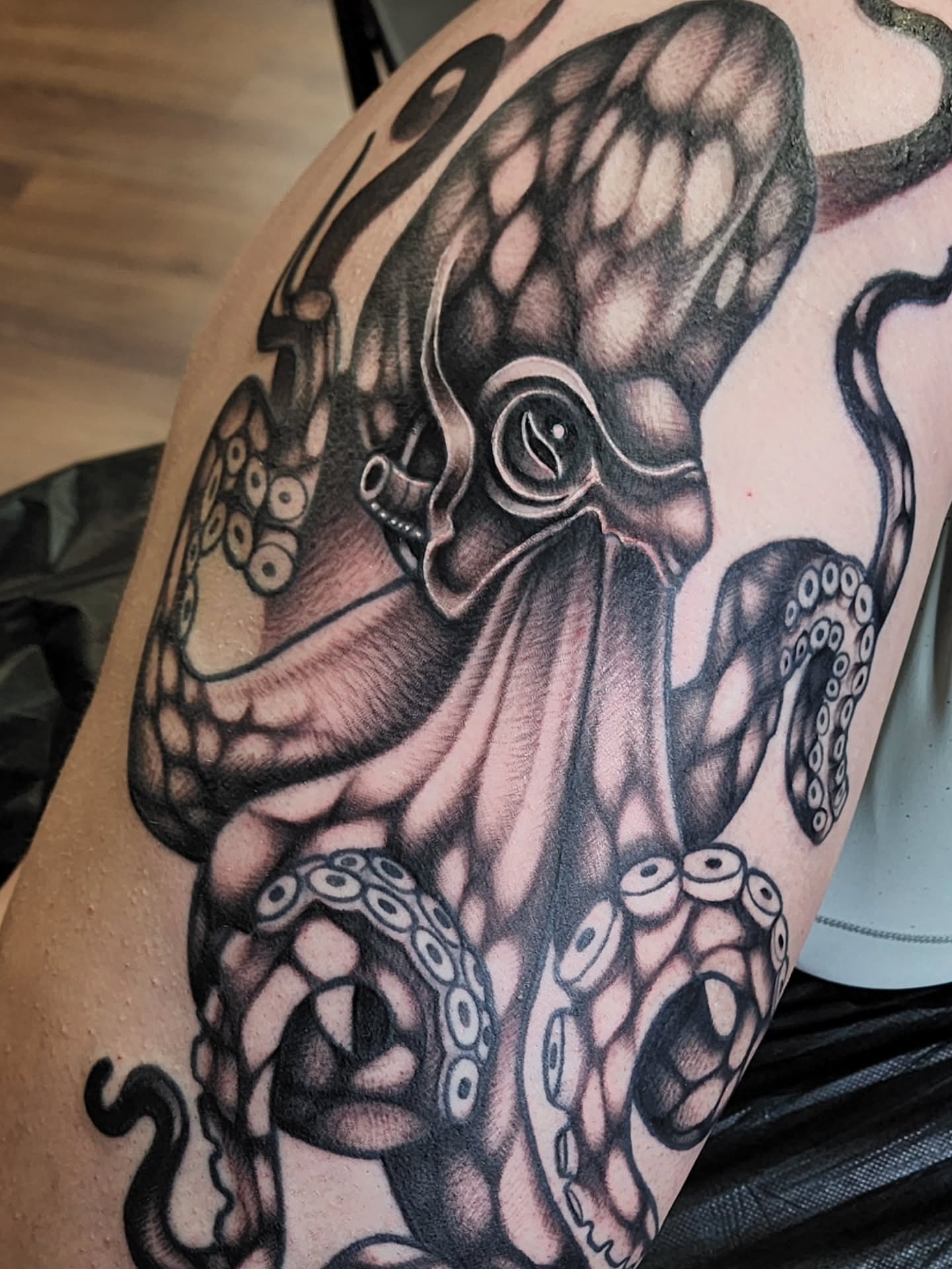 Octopus black and grey tattoo on the upper arm by Shawna Goettsche