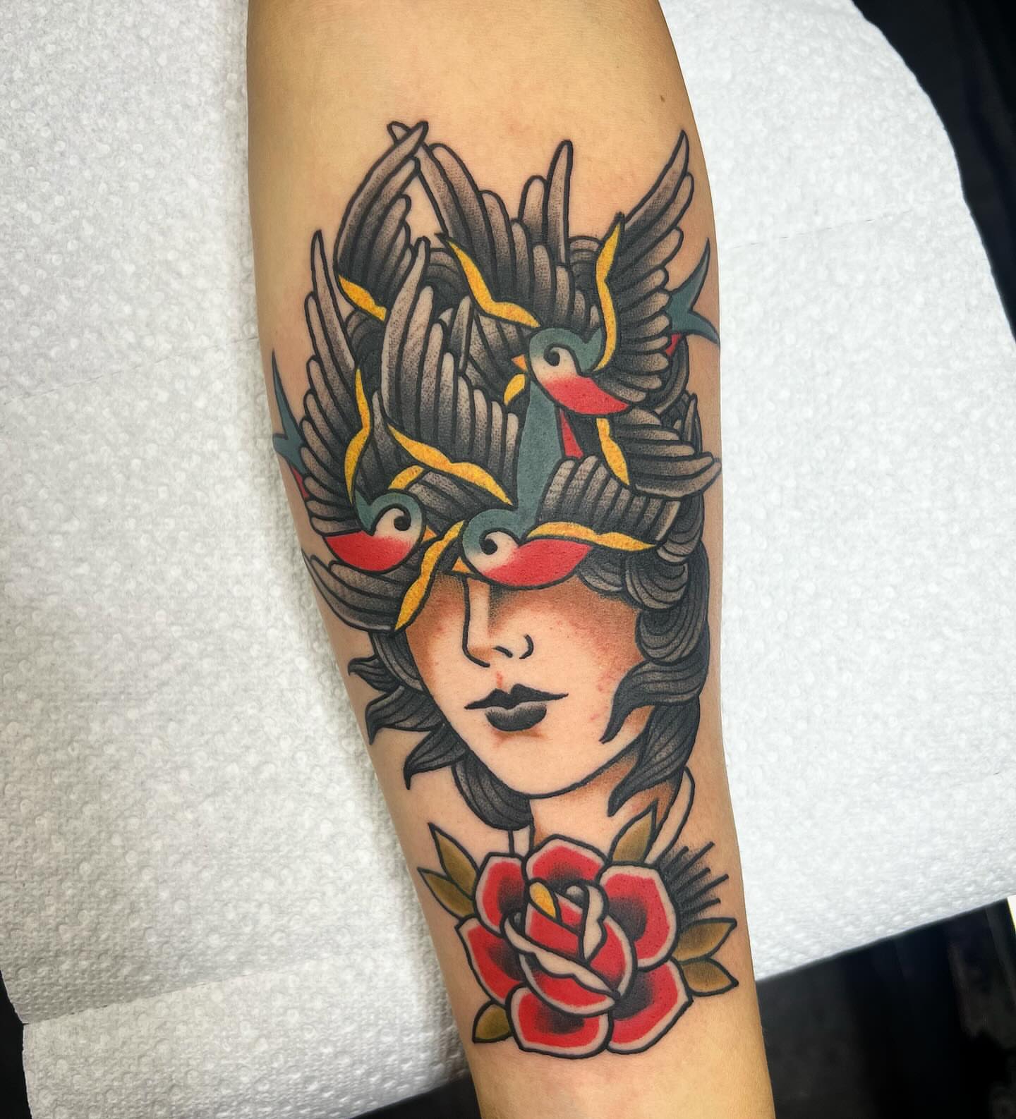 Woman with birds and rose American traditional tattoo on the forearm by Taylor Estrella