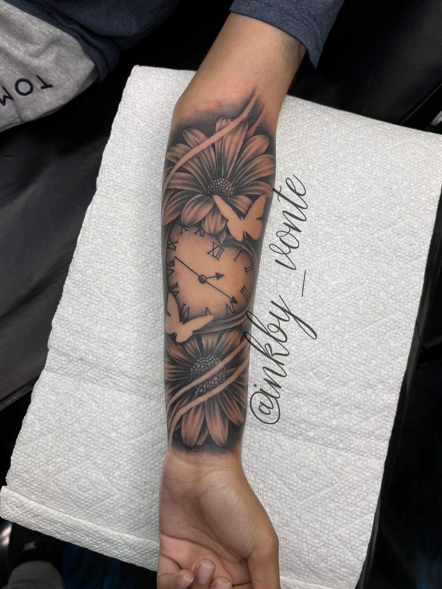 Clock and flower black and grey tattoo on the forearm by Vonte Seay