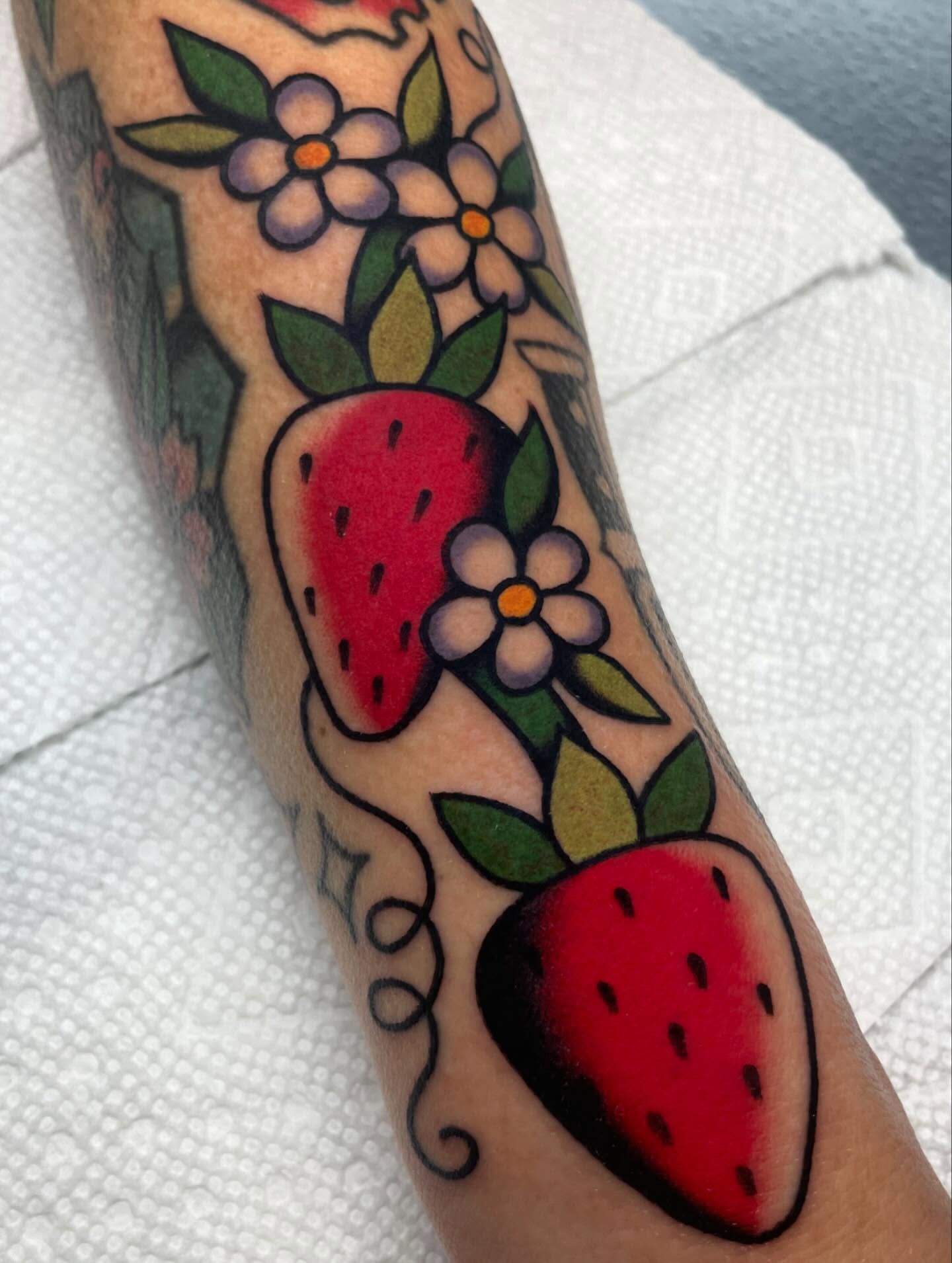 Strawberries and flowers American traditional tattoo on the forearm by Nova Vaughn