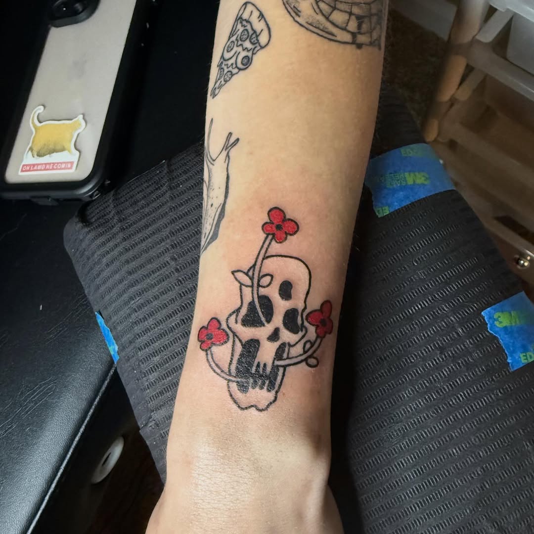 Skull with flowers American traditional tattoo on the forearm by Danny Garcia