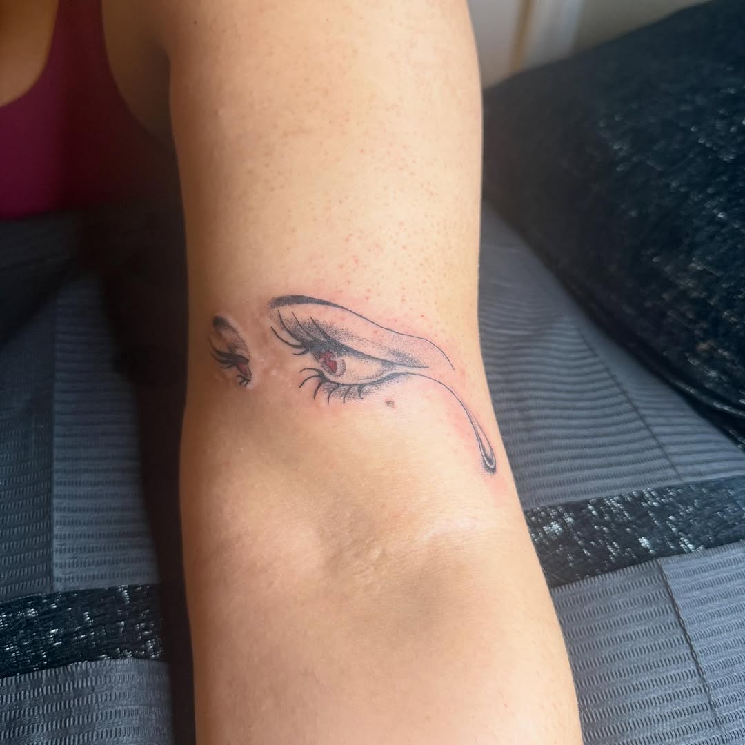 Crying eye surrealism tattoo on the forearm by Danny Garcia