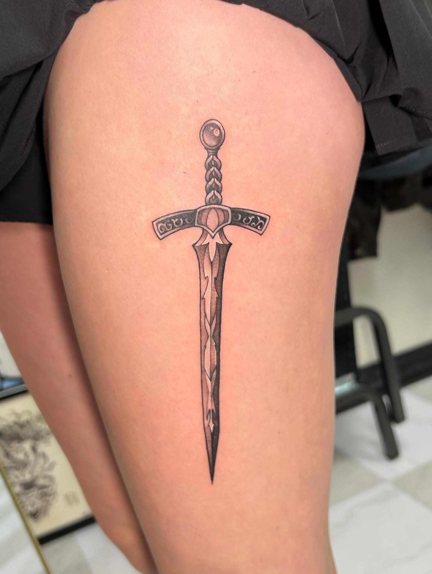 Sword black and grey tattoo on the thigh by kuna ink
