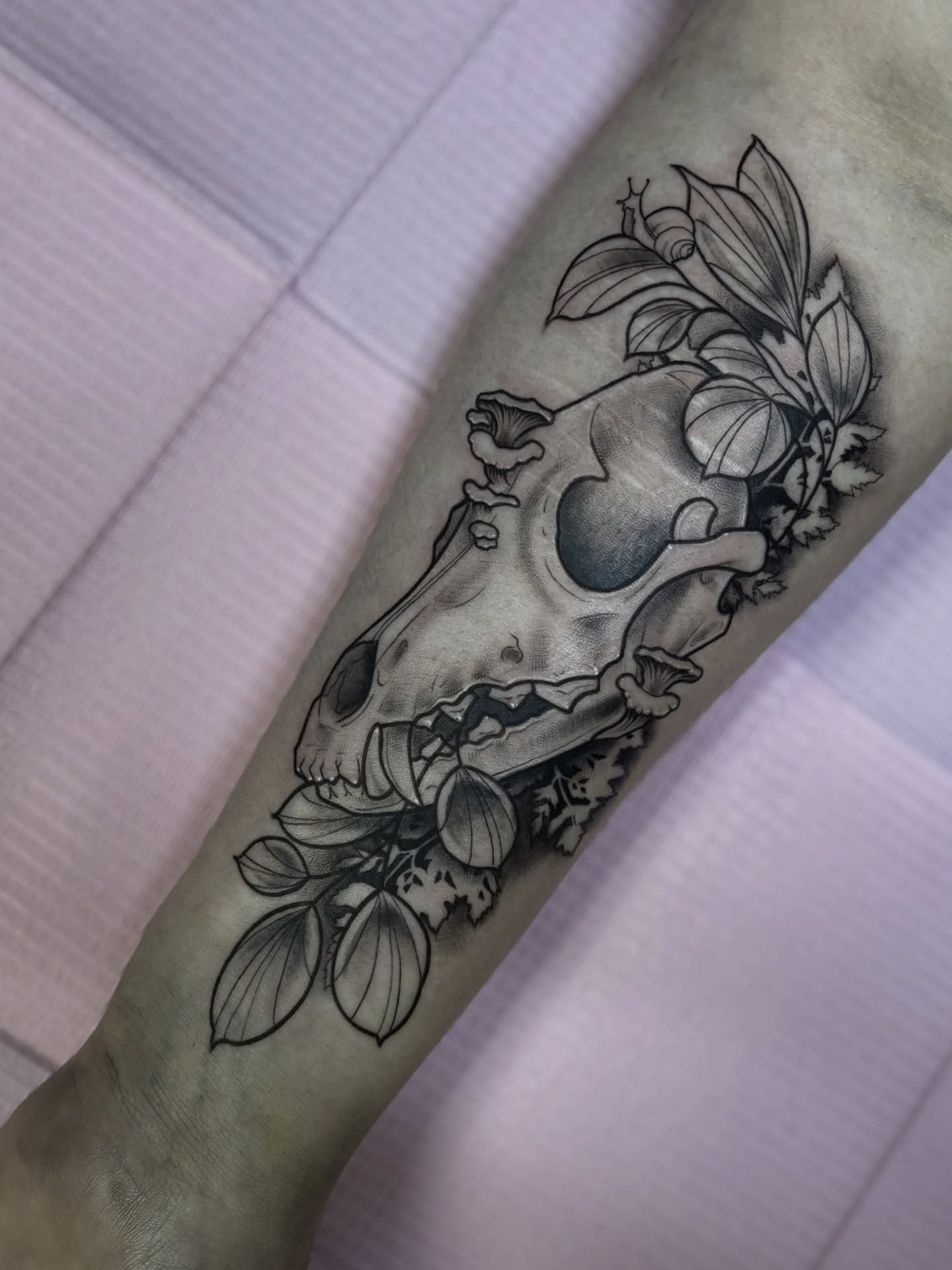Skull and floral realism tattoo on the forearm by Elixabeth