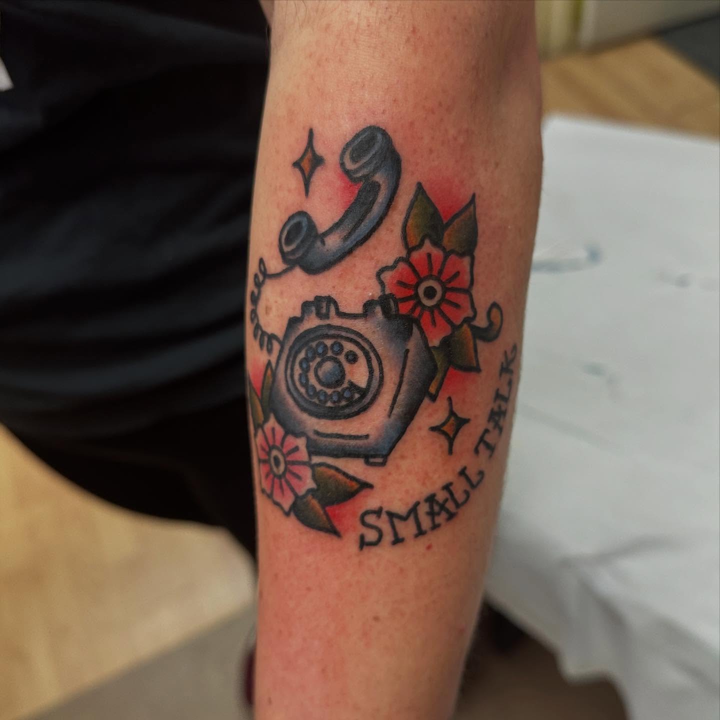 Telephone and flowers American traditional tattoo on the forearm by norawillstattoo