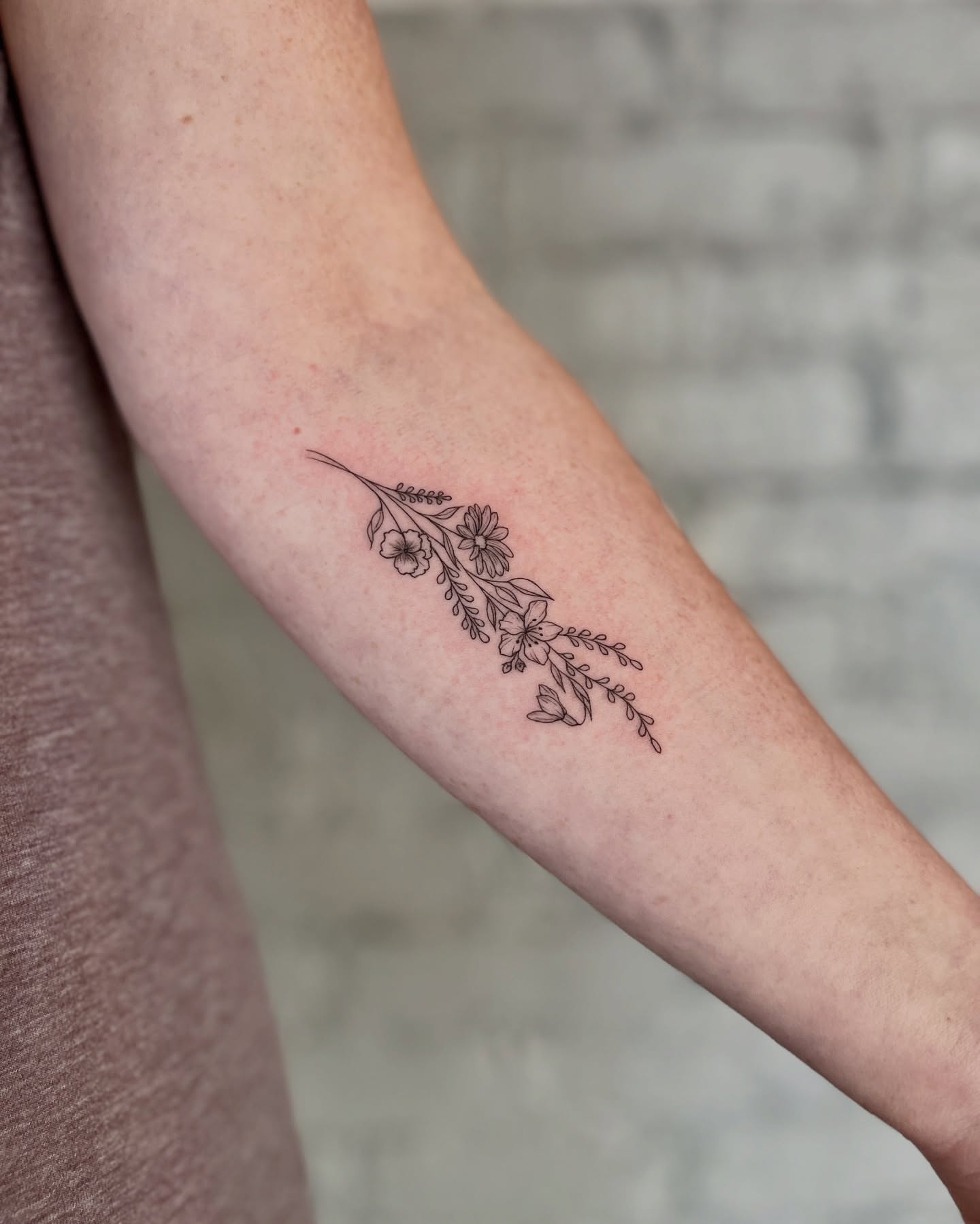 Floral arrangement fine line tattoo on the forearm by Ruby ♥️