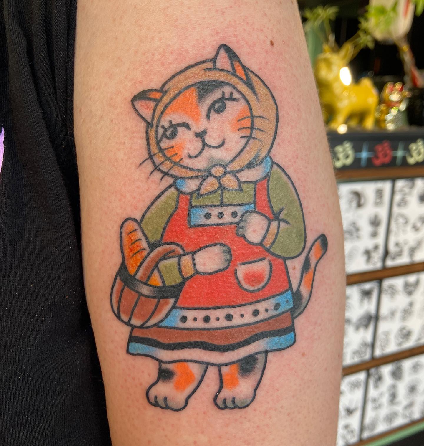 Cat in apron dotwork tattoo on the forearm by Lucía