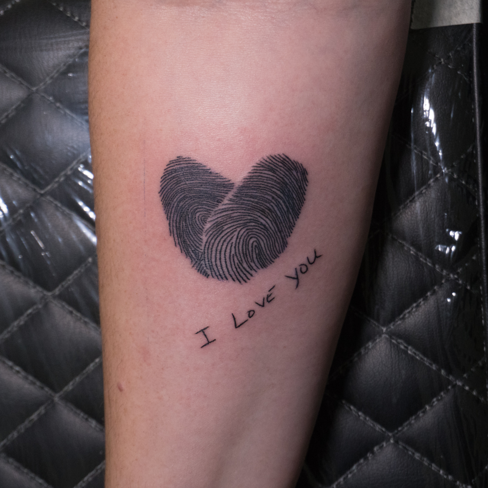 Fingerprint heart black and grey tattoo on the forearm by Donald Voelker