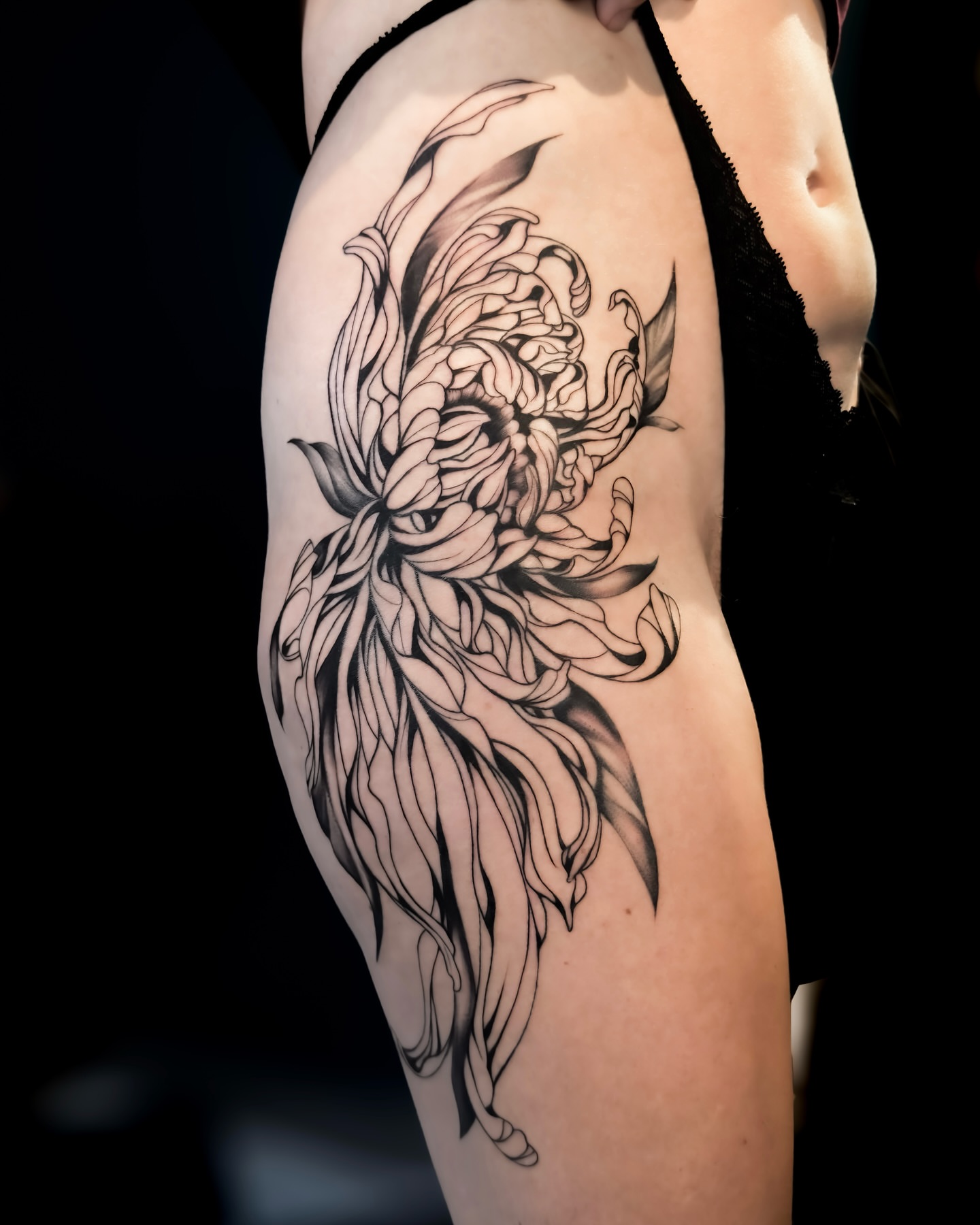 Chrysanthemum black and grey tattoo on the thigh by Amelia