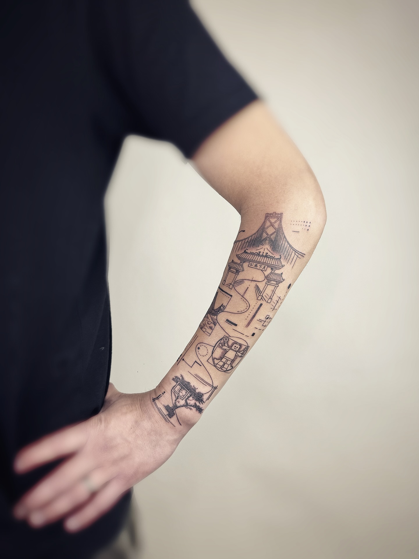 Bridge and hieroglyphs black and grey tattoo on the forearm by Jadyn Pang
