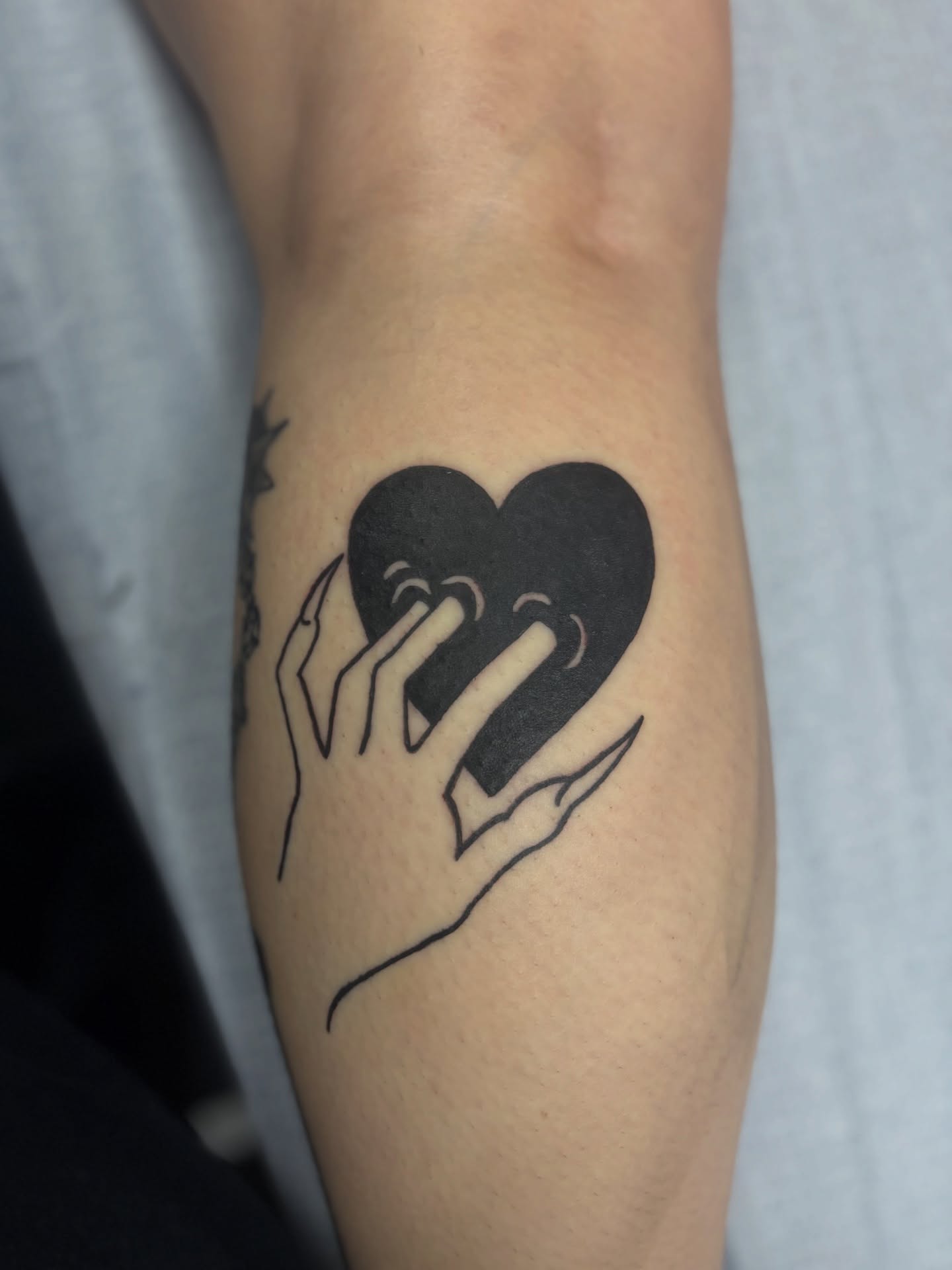 Heart with hands minimalist tattoo on the forearm by Rachel