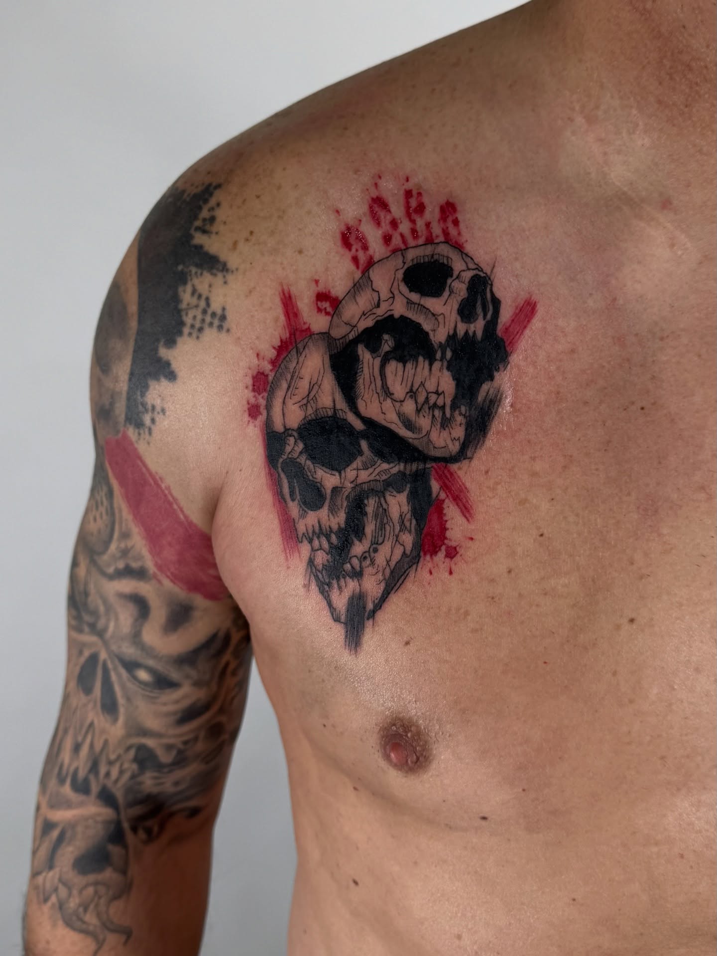 Skulls black and grey tattoo on the chest by sabina