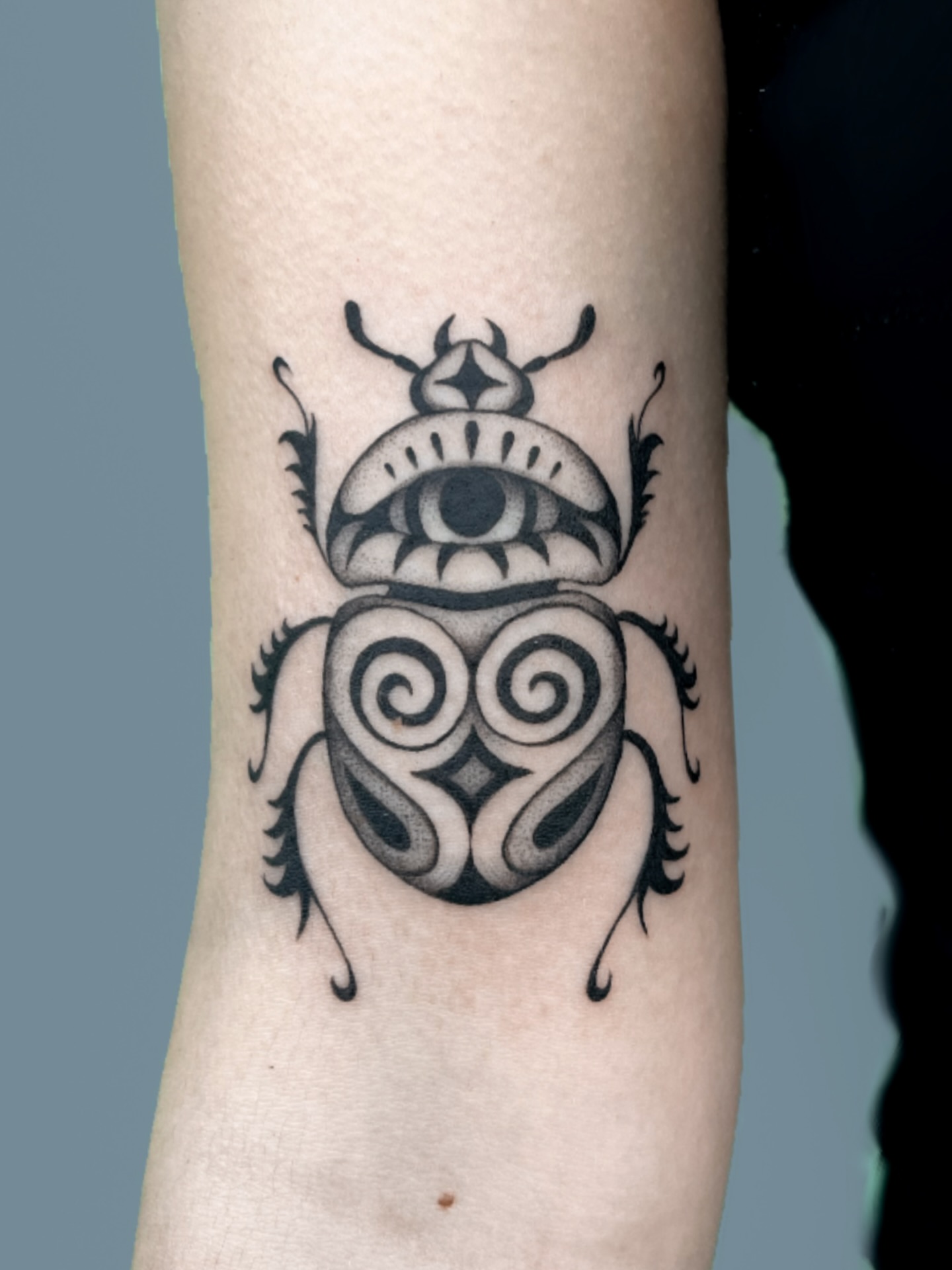 Scarab beetle black and grey tattoo on the forearm by nina