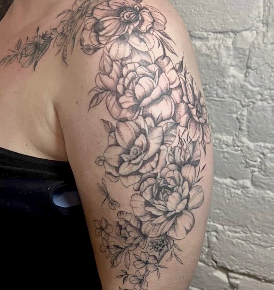Floral bouquet realism tattoo on the upper arm by Sydney Gallucci