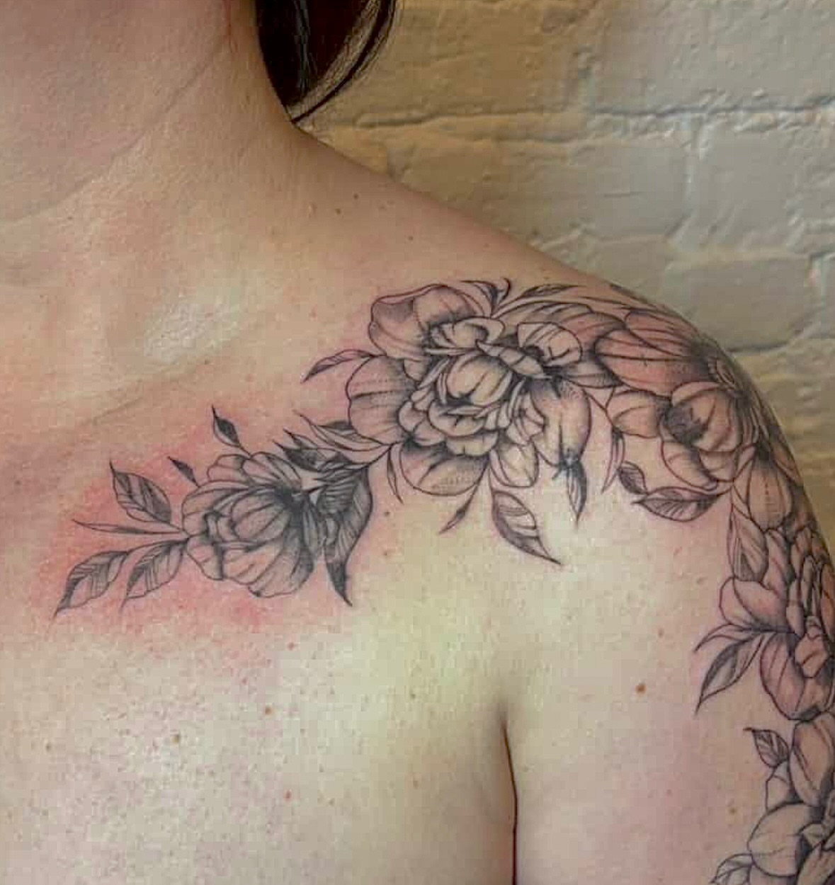 Floral bouquet black and grey tattoo on the shoulder by Sydney Gallucci