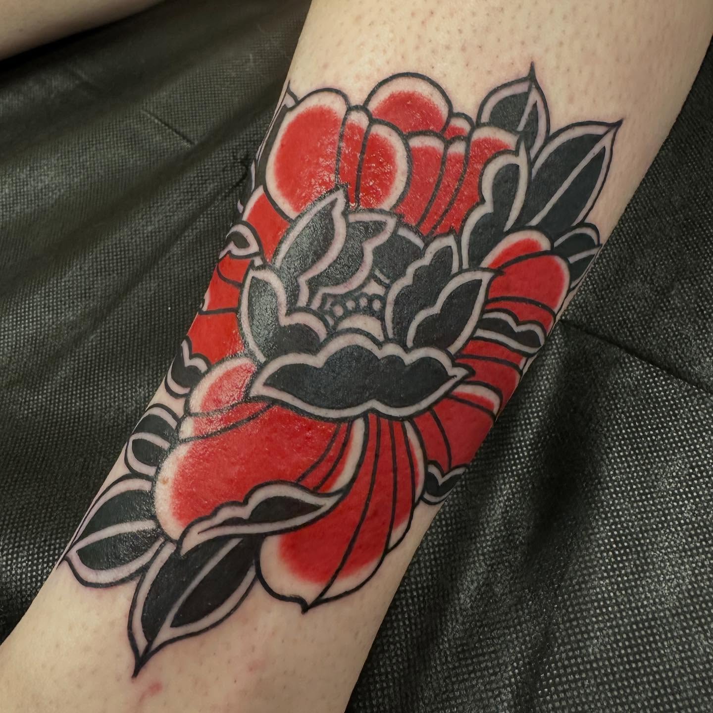 Red rose American traditional tattoo on the forearm by Katie Beth