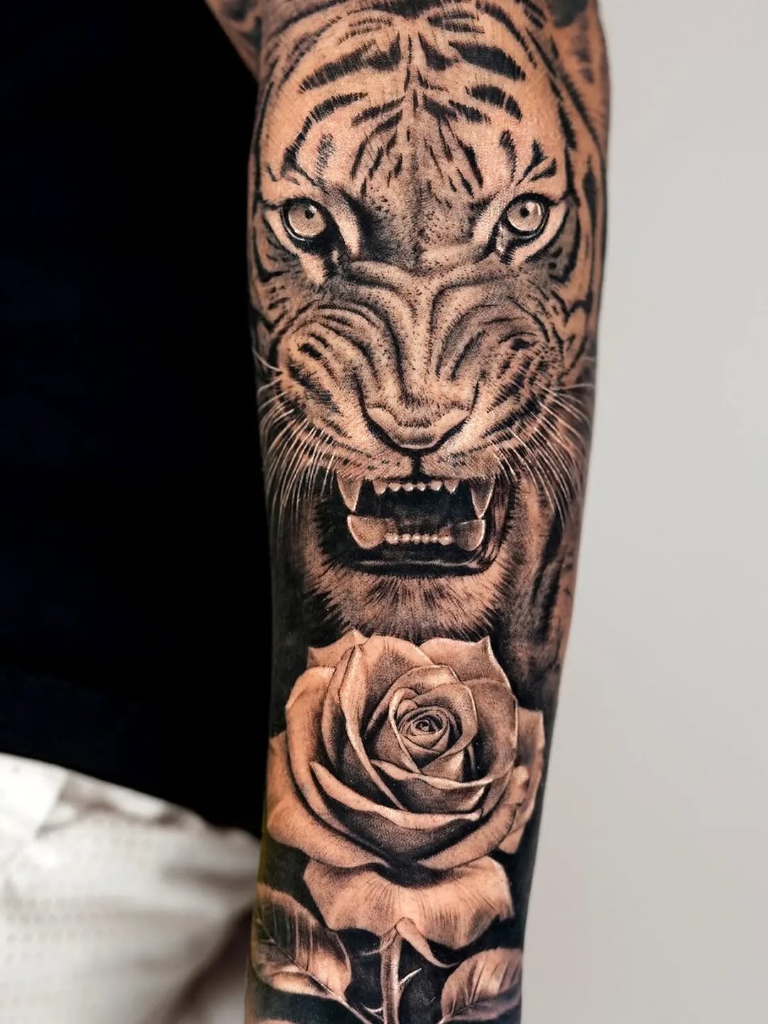 Tiger and rose realism tattoo on the forearm by Jun