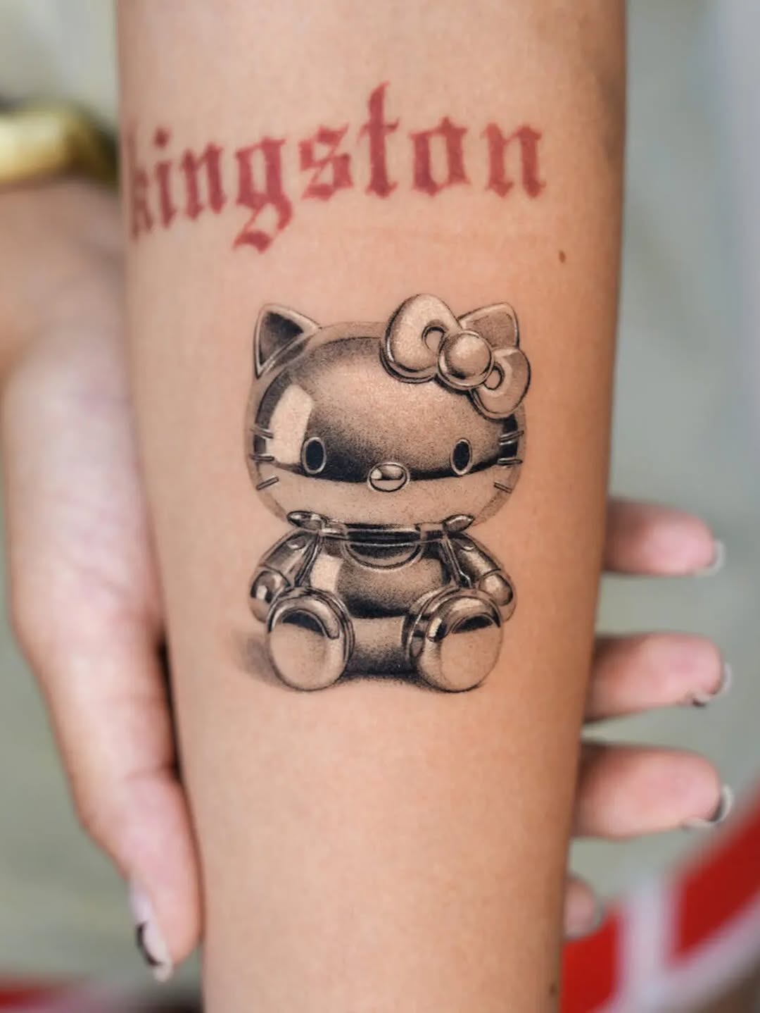 Hello Kitty figurine realism tattoo on the forearm by Jun