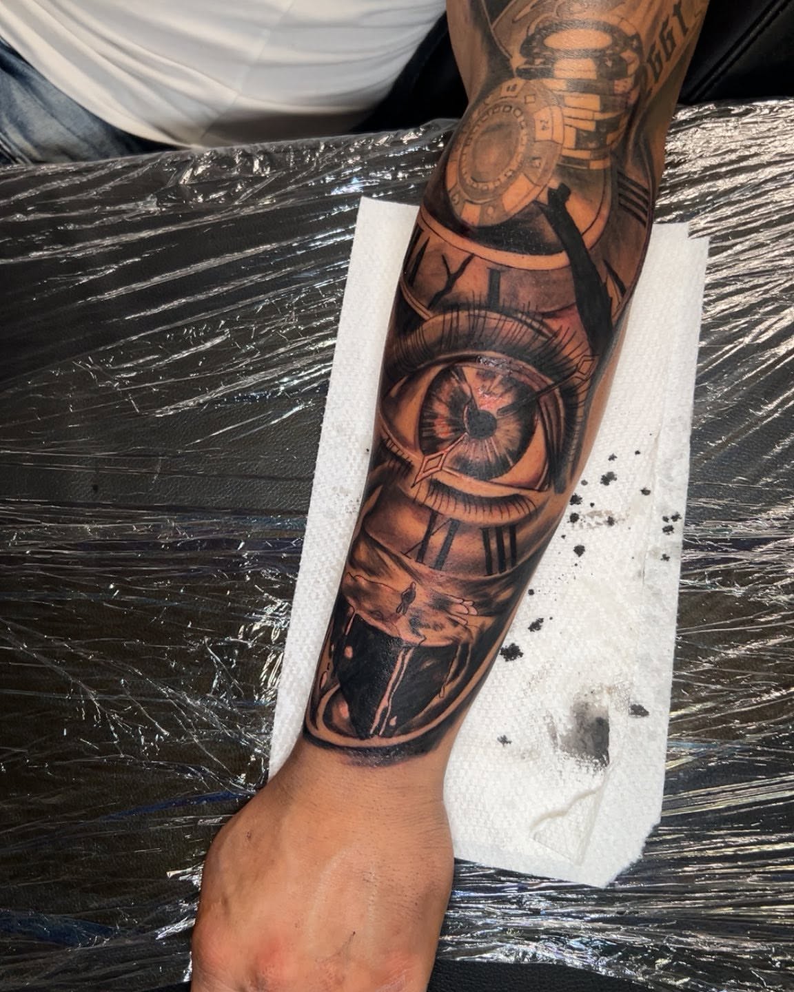 Eye and clockwork realism tattoo on the forearm by Bryant Ramirez