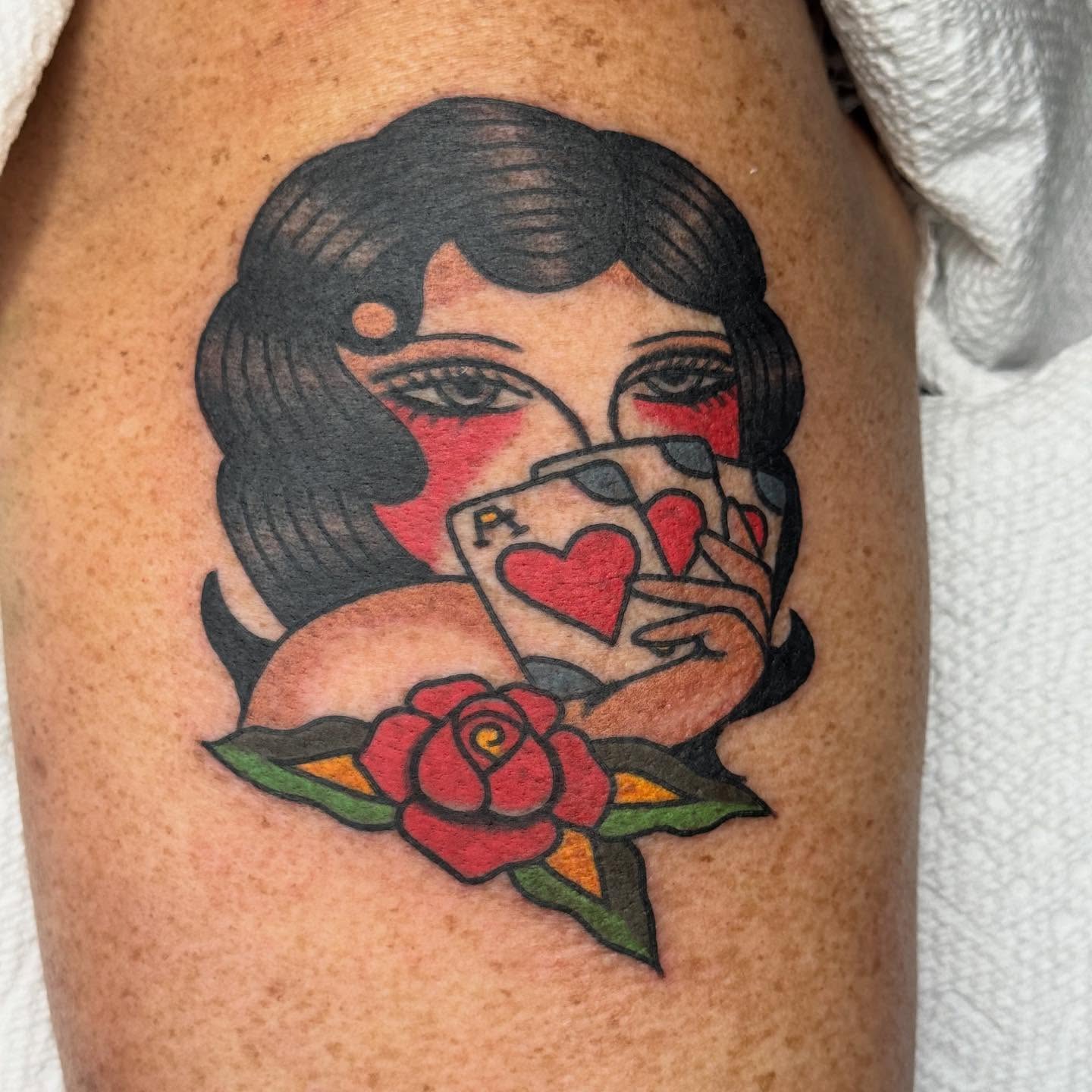 Woman with playing card American traditional tattoo on the thigh by JoJo Benton