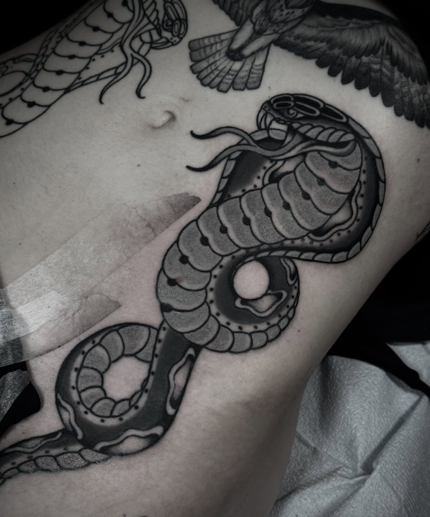 Snake black and grey tattoo on the thigh by Ally noel