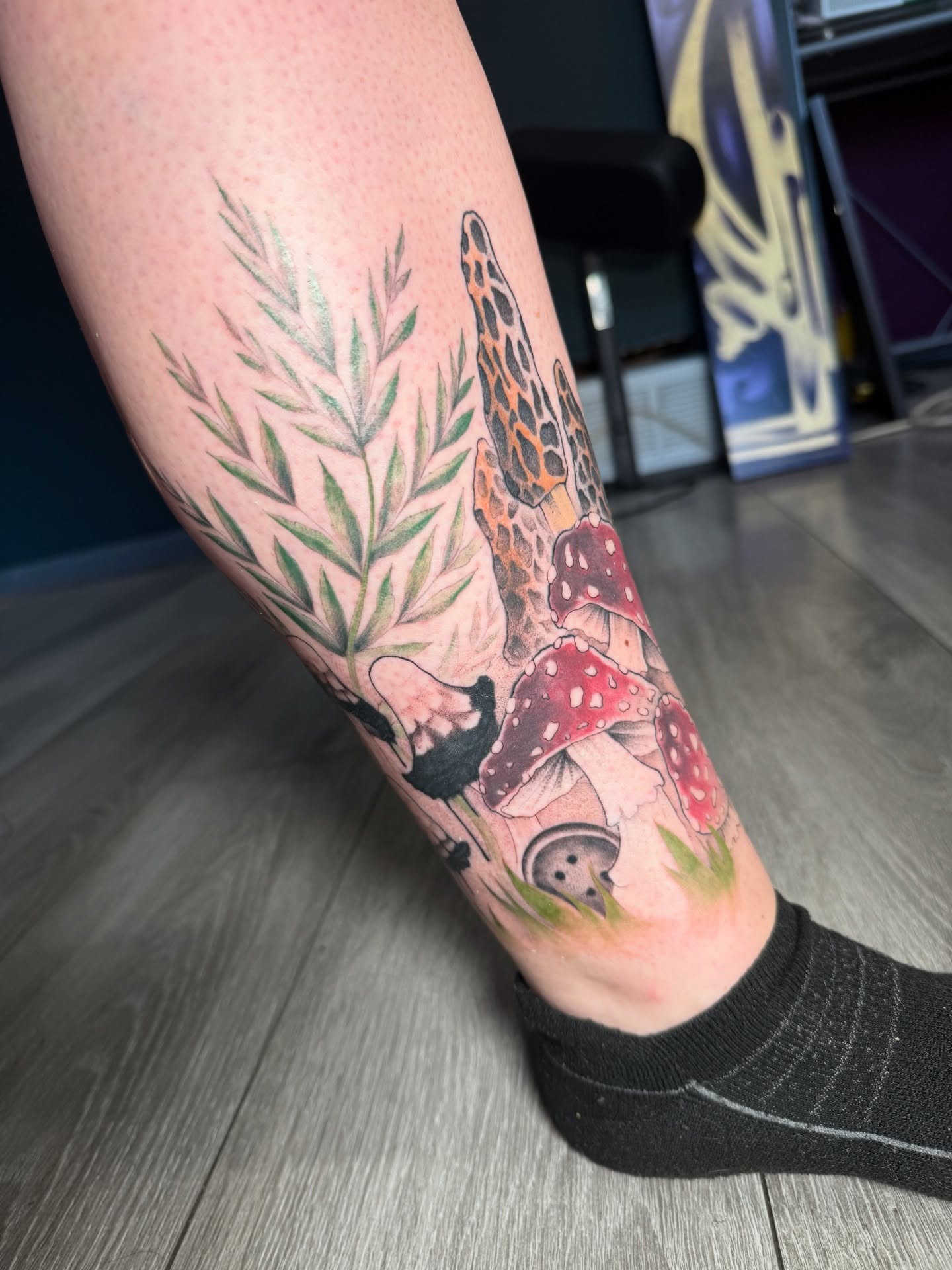 Mushroom and foliage realism tattoo on the calf by Tayler Beetison