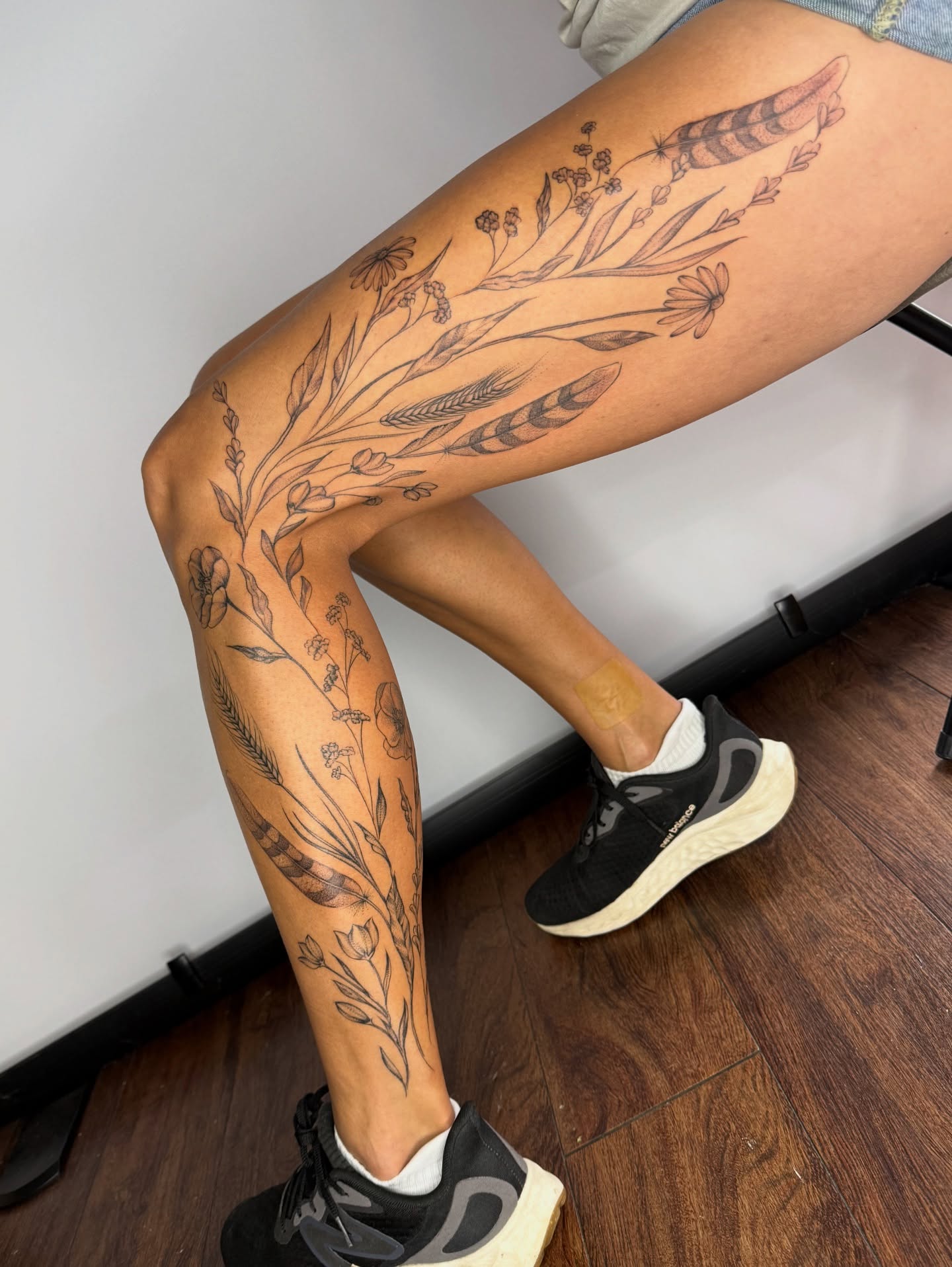 Floral arrangement black and grey tattoo on the thigh by Brandie