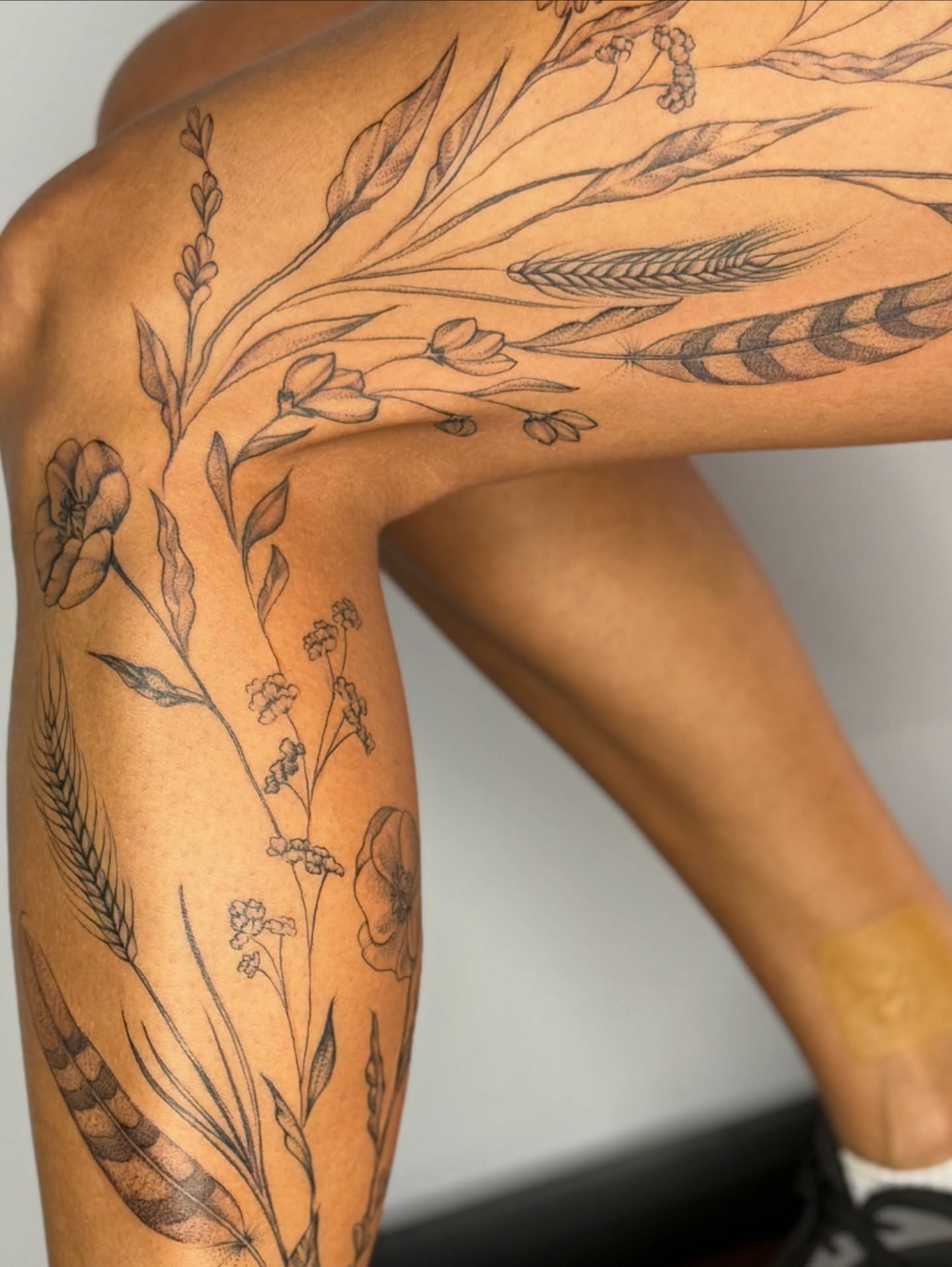 Floral arrangement black and grey tattoo on the upper arm by Brandie