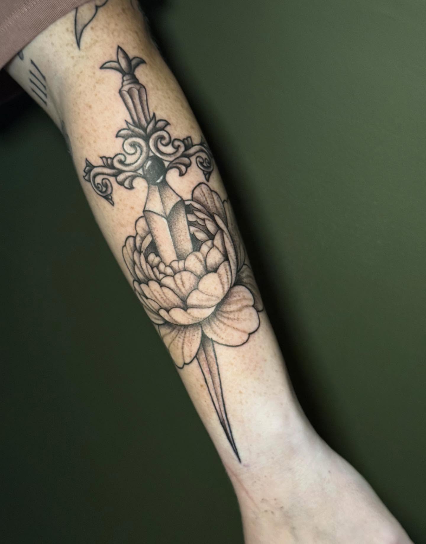 Cross and flower black and grey tattoo on the forearm by Whimsical illustrative