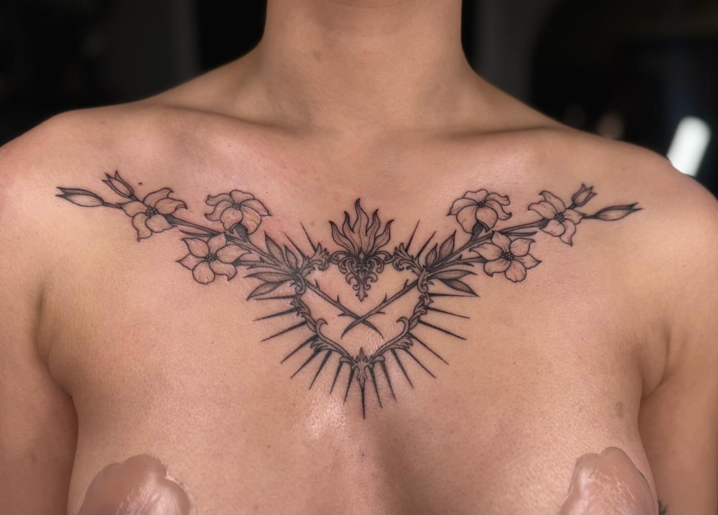 Heart with thorns and flowers ornamental tattoo on the chest by Koko