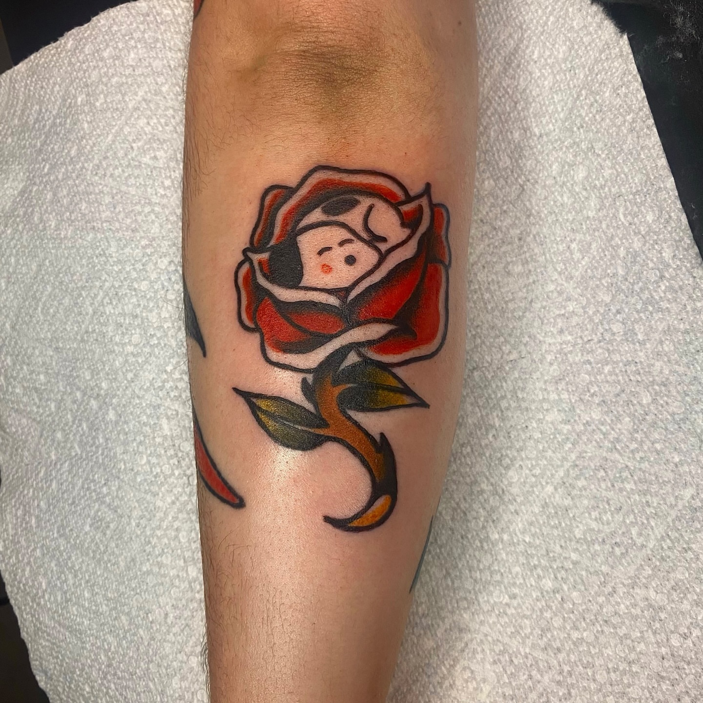 Rose with face American traditional tattoo on the forearm by Myka King