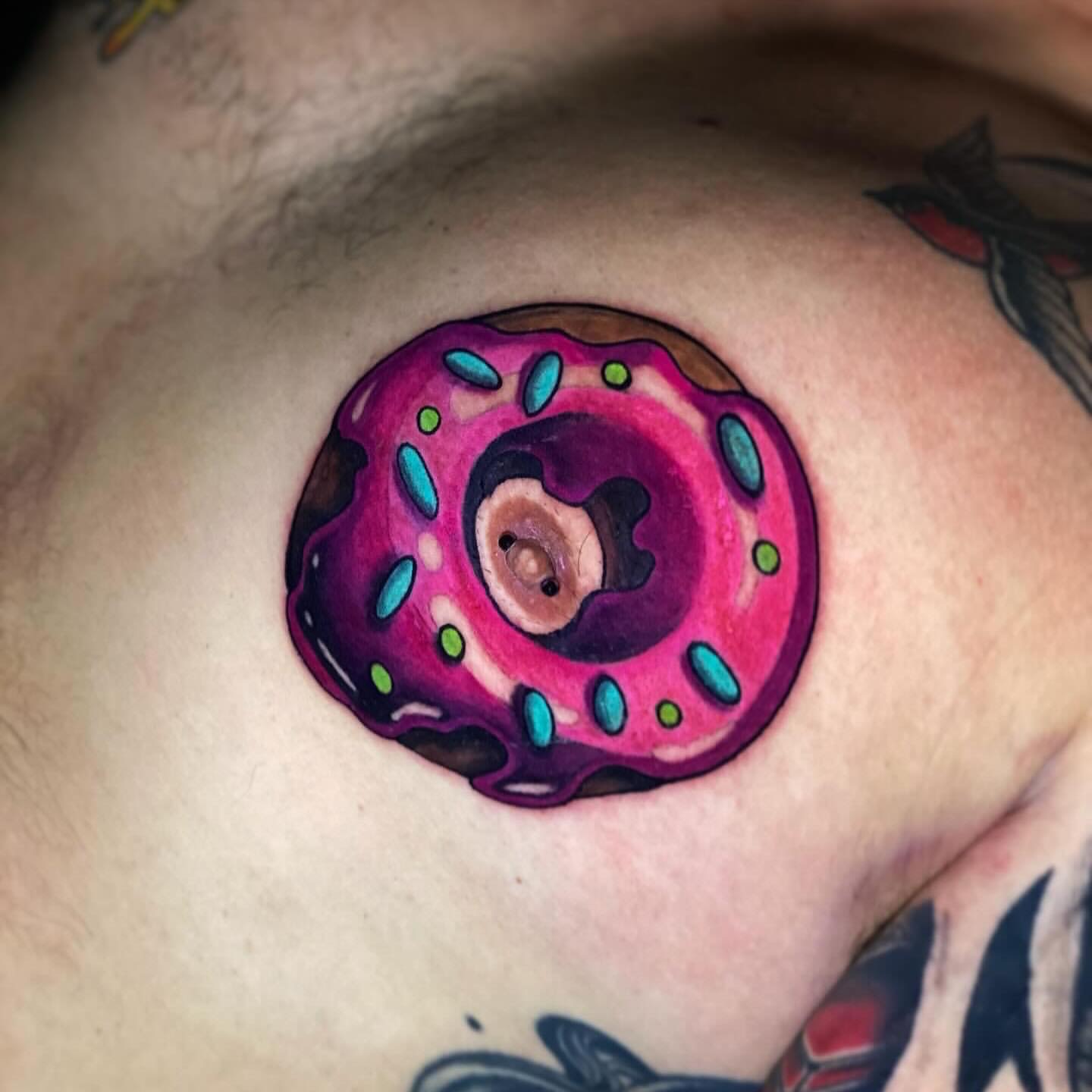 Donut new school tattoo on the chest by Lindsay Hall