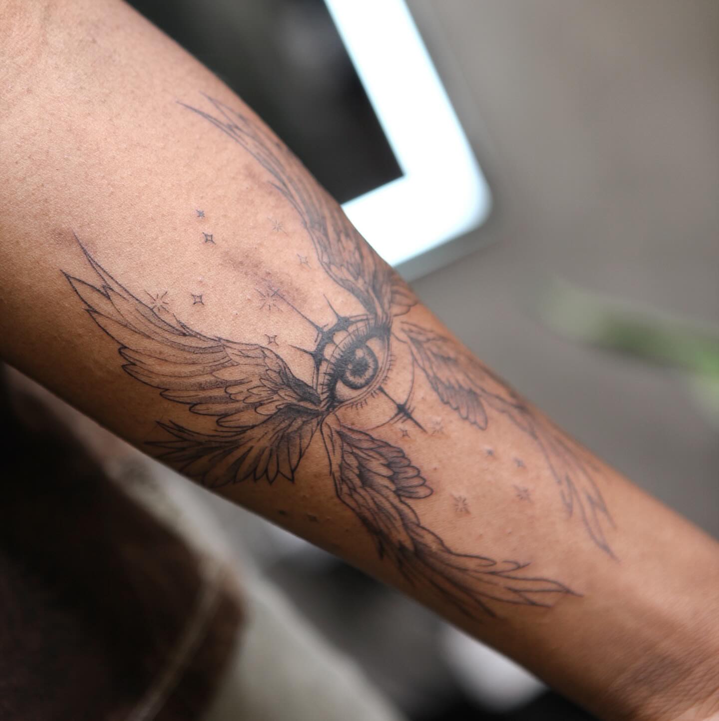 Eye with wings black and grey tattoo on the forearm by Liv