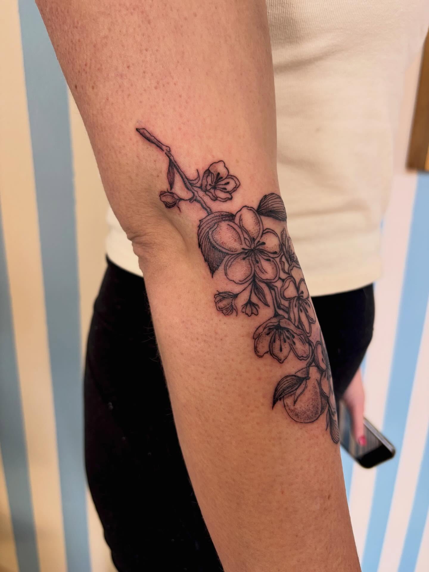 Cherry blossoms black and grey tattoo on the forearm by Ashley Ellerman