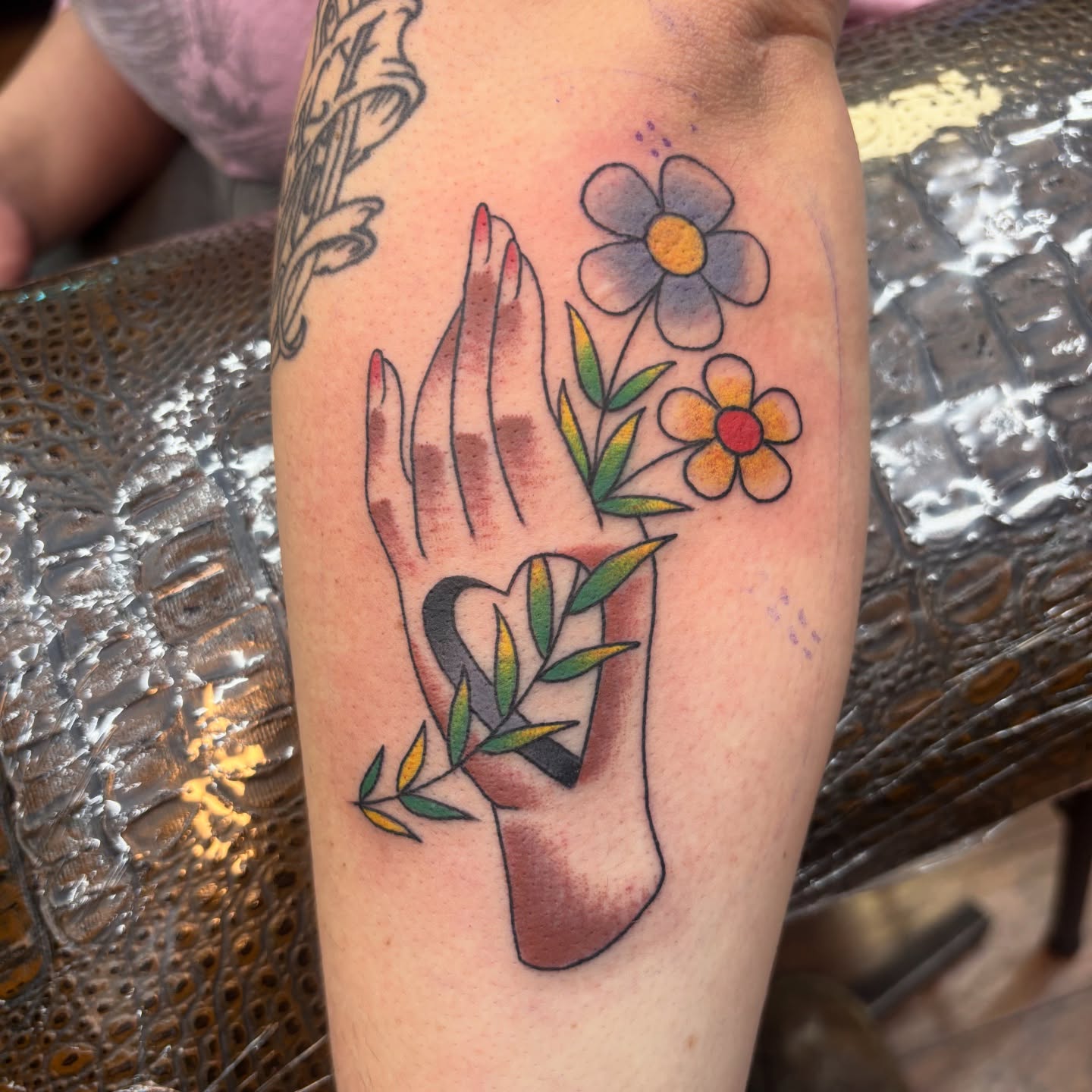 Hands and flowers new school tattoo on the forearm by Jordan Wray