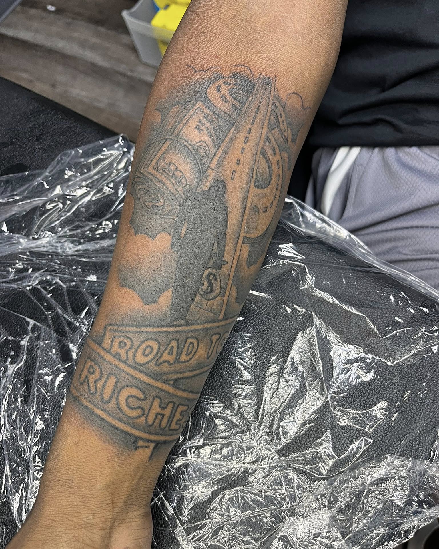 Road to riches black and grey tattoo on the forearm by Ferlandis Fitch, Long Beach, California