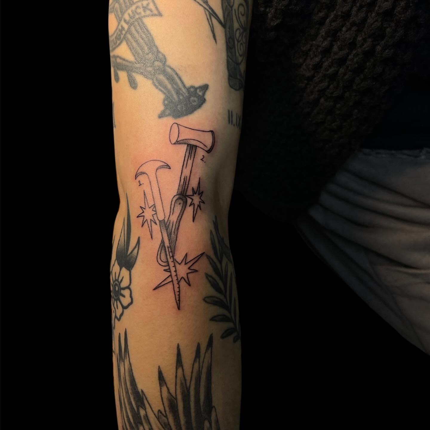 Axe and hammer black and grey tattoo on the forearm by Brooke Kresco
