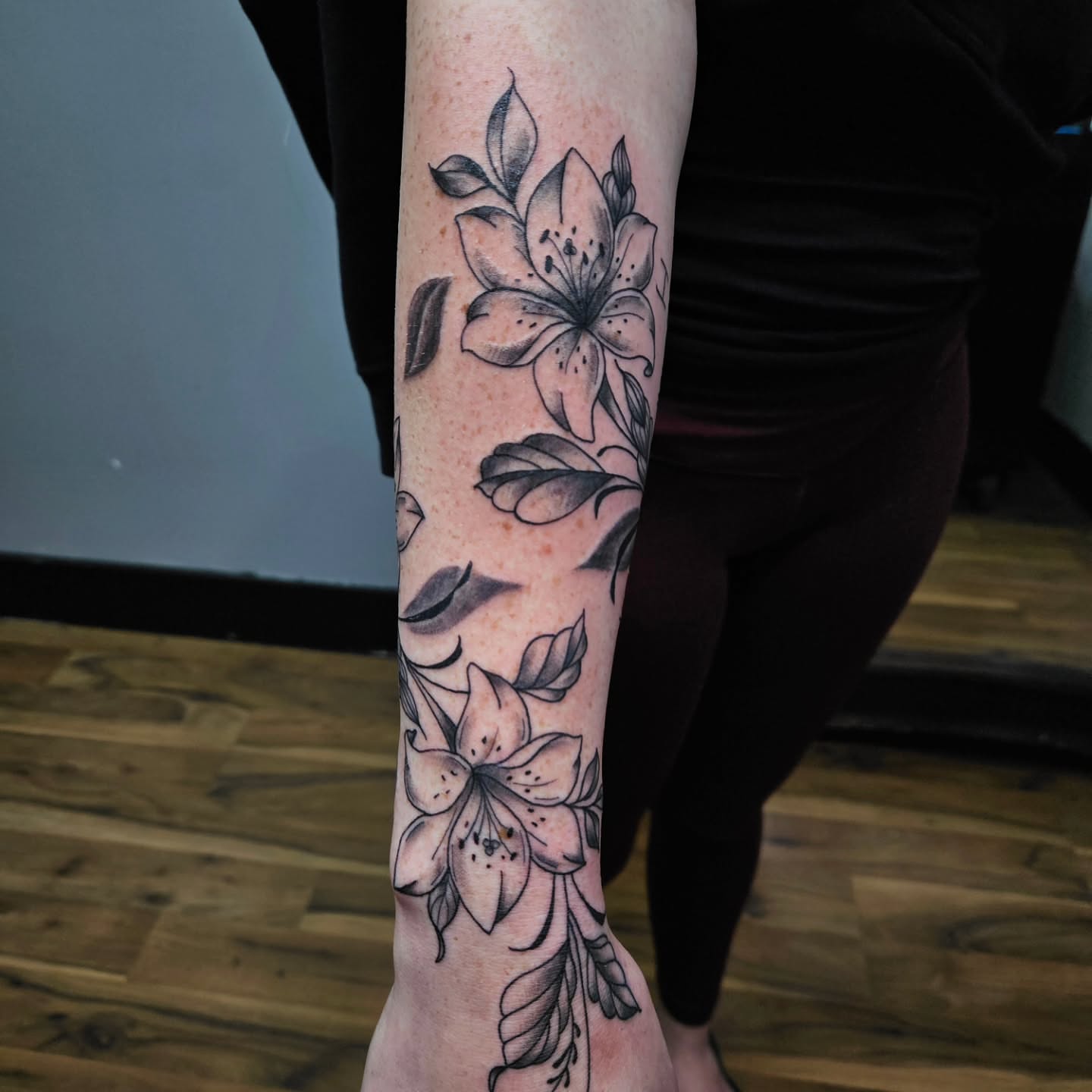 Lily flowers black and grey tattoo on the forearm by Danny
