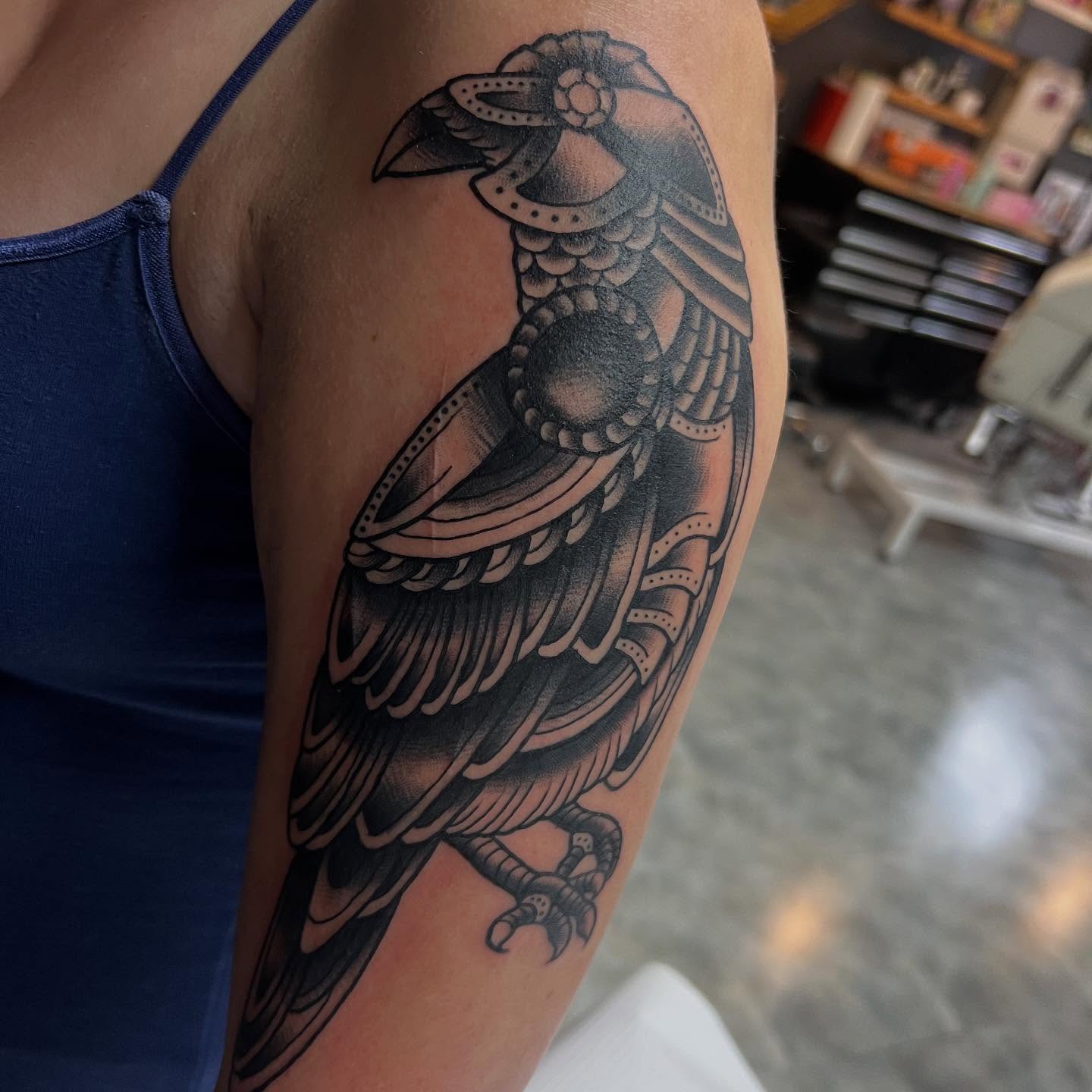 Crow black and grey tattoo on the upper arm by doodle