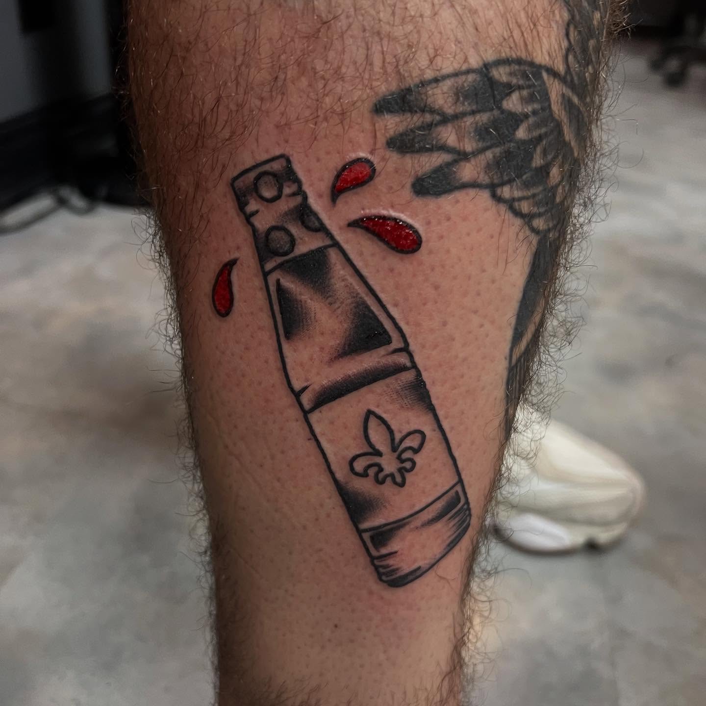 Shotgun and fleur-de-lis black and grey tattoo on the leg by doodle