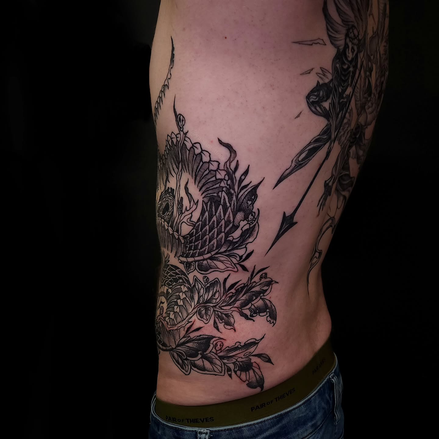 Pineapple and leaves black and grey tattoo on the thigh by Sheena Yu-Hsin Wood