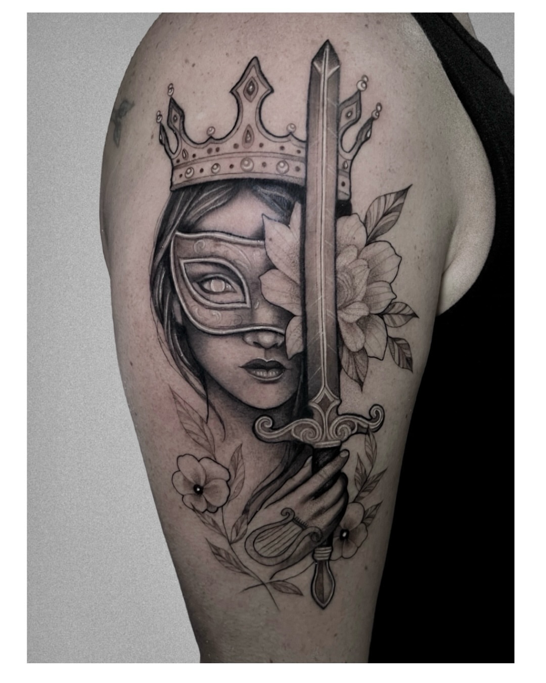 Mask-wearing woman with sword realism tattoo on the forearm by Jordyn Tinney