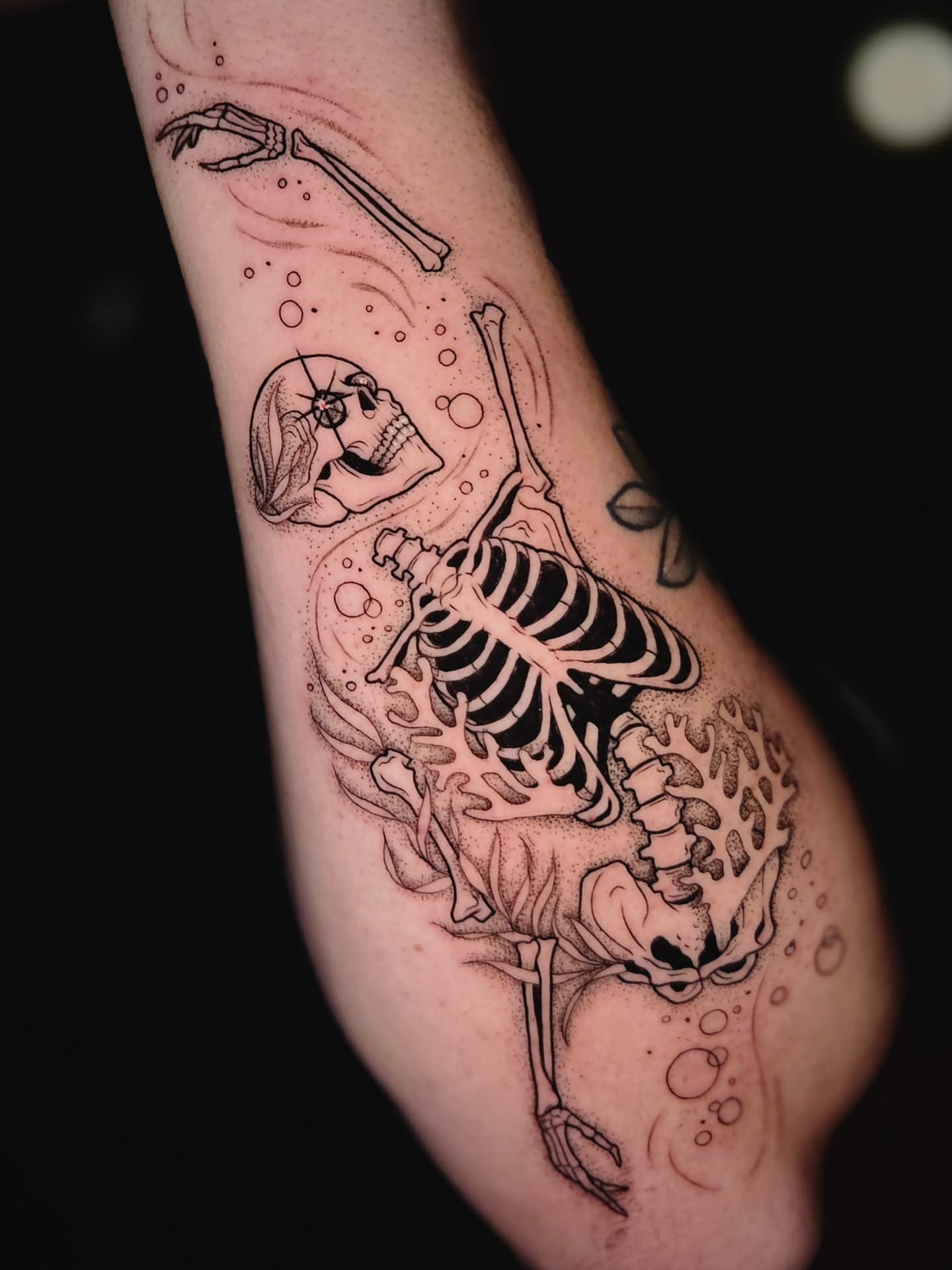 Skeleton diving realism tattoo on the forearm by Courtlyn Bliss