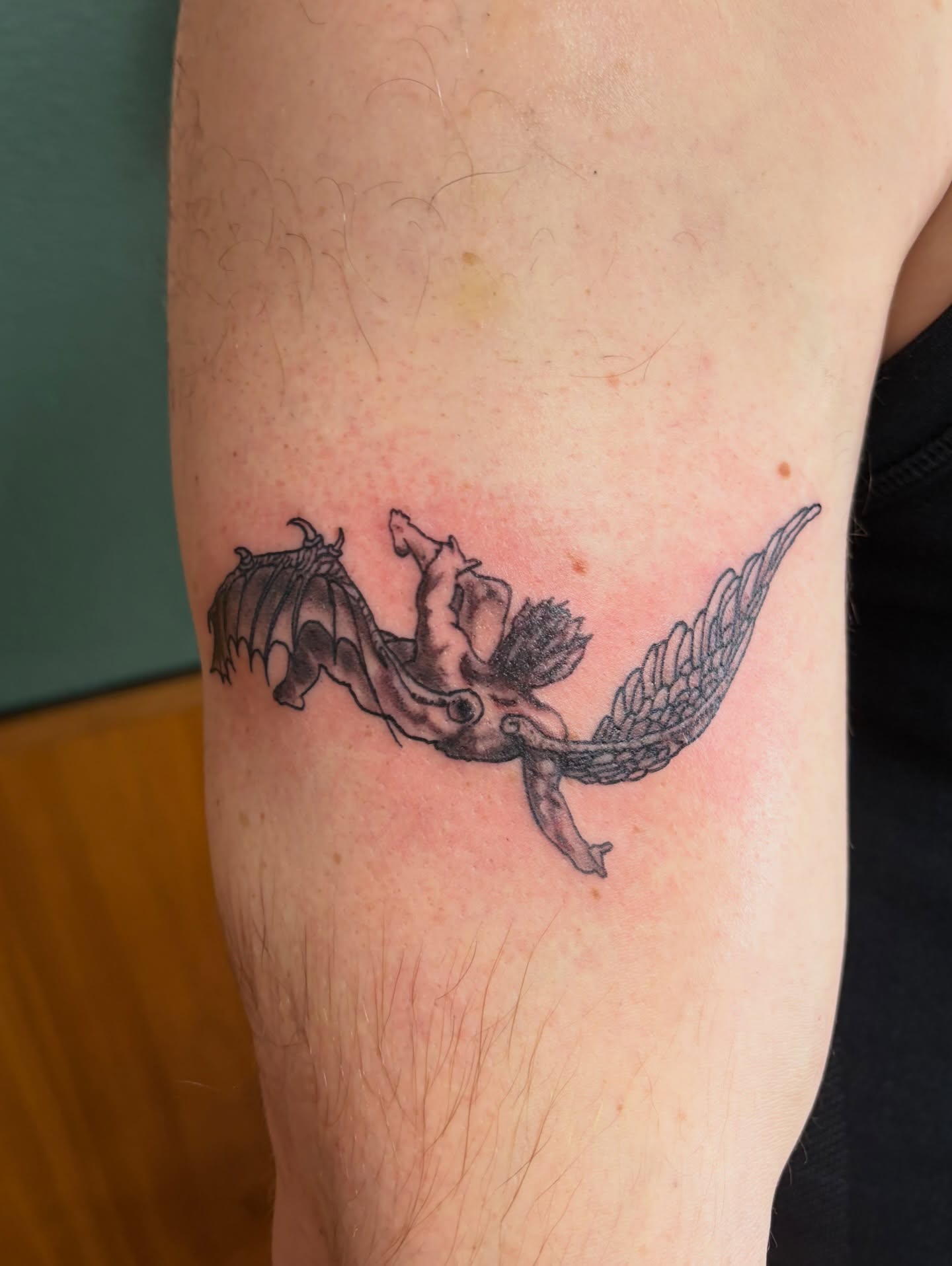 Angel and dragon black and grey tattoo on the forearm by Michelle