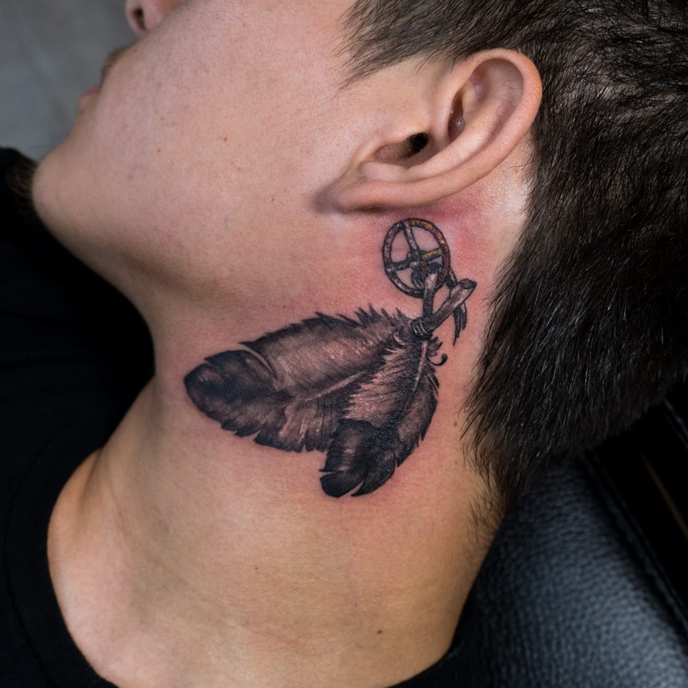 Feather and compass black and grey tattoo on the neck by Donald Voelker