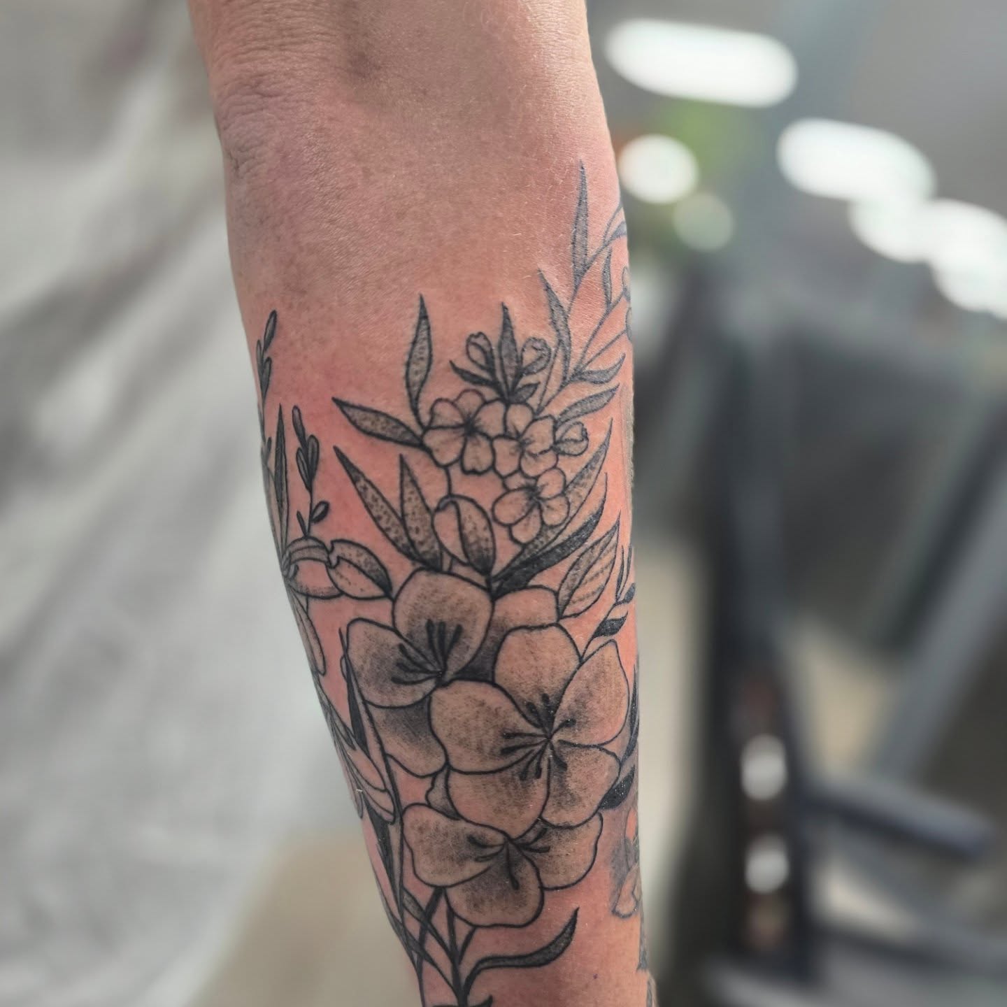 Floral bouquet black and grey tattoo on the forearm by Karen Cain