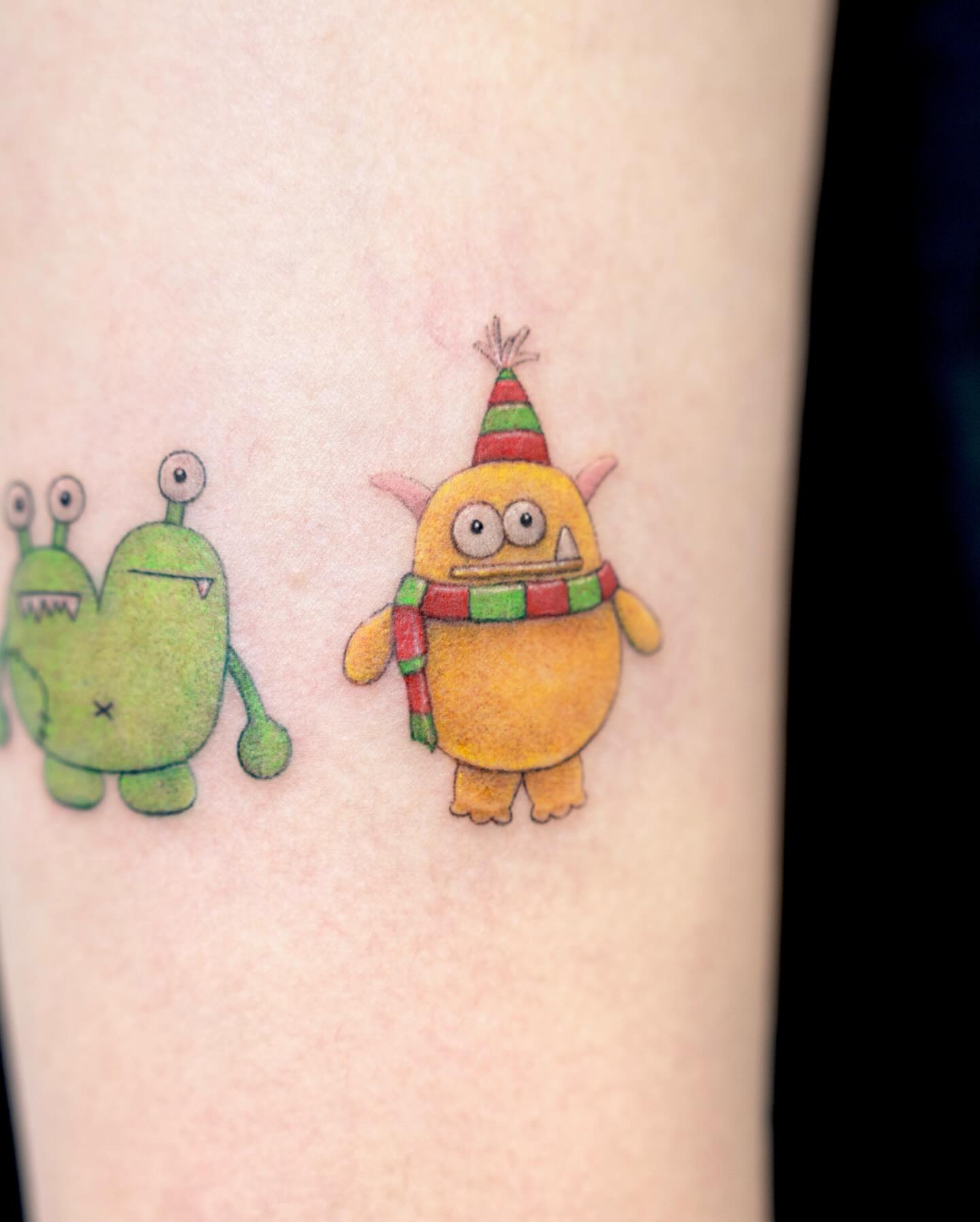 Two cartoon monsters illustrative tattoo on the forearm by Zeeyo 지요