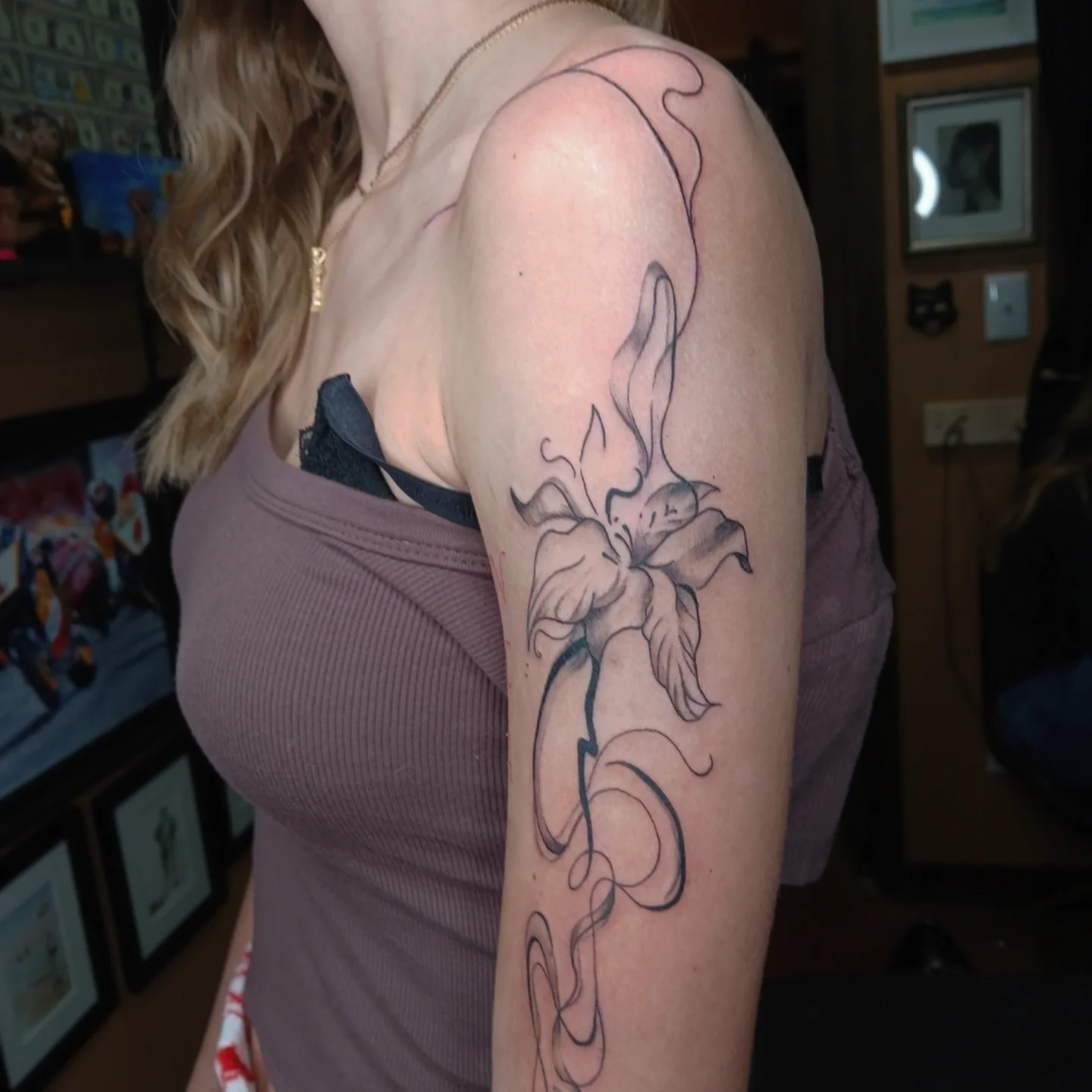 Lily black and grey tattoo on the upper arm by Chris Bell