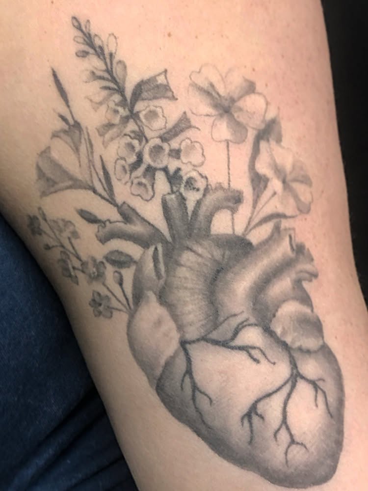 Anatomical heart with flowers realism tattoo on the thigh by Cassandra Colleen