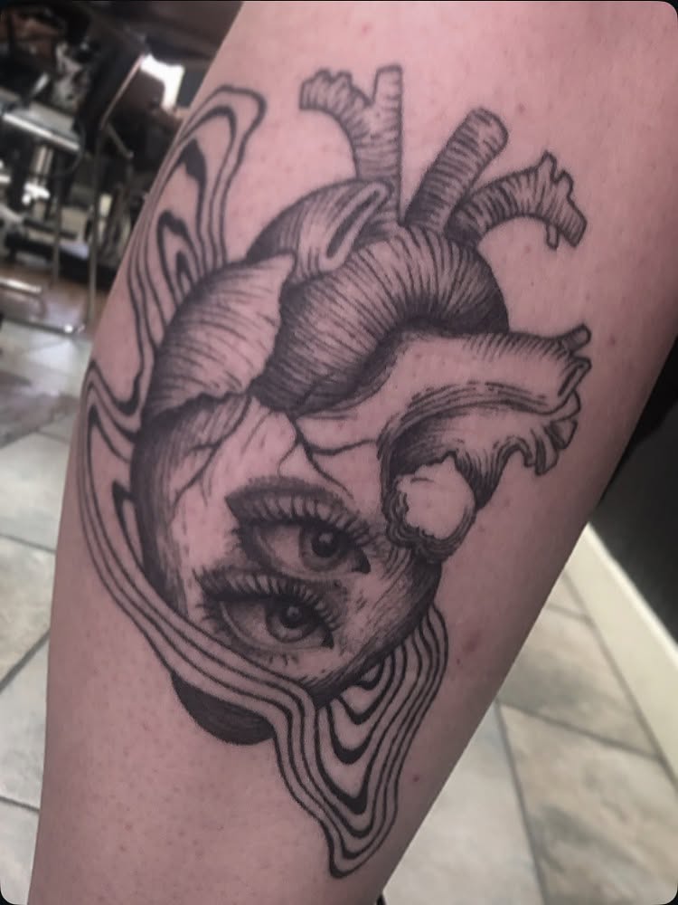 Heart with eye realism tattoo on the forearm by Cassandra Colleen